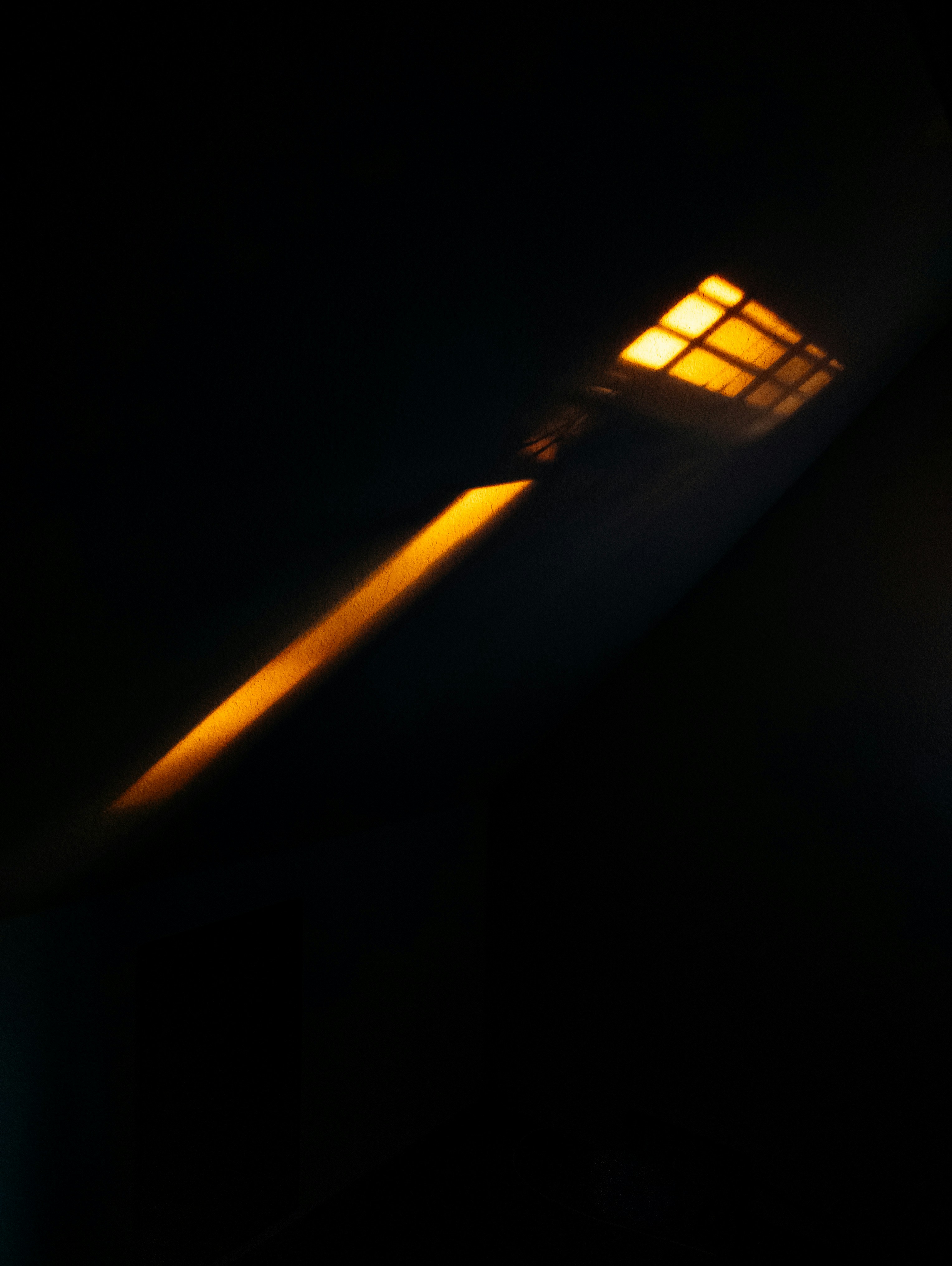 A single light source casts a bright orange glow