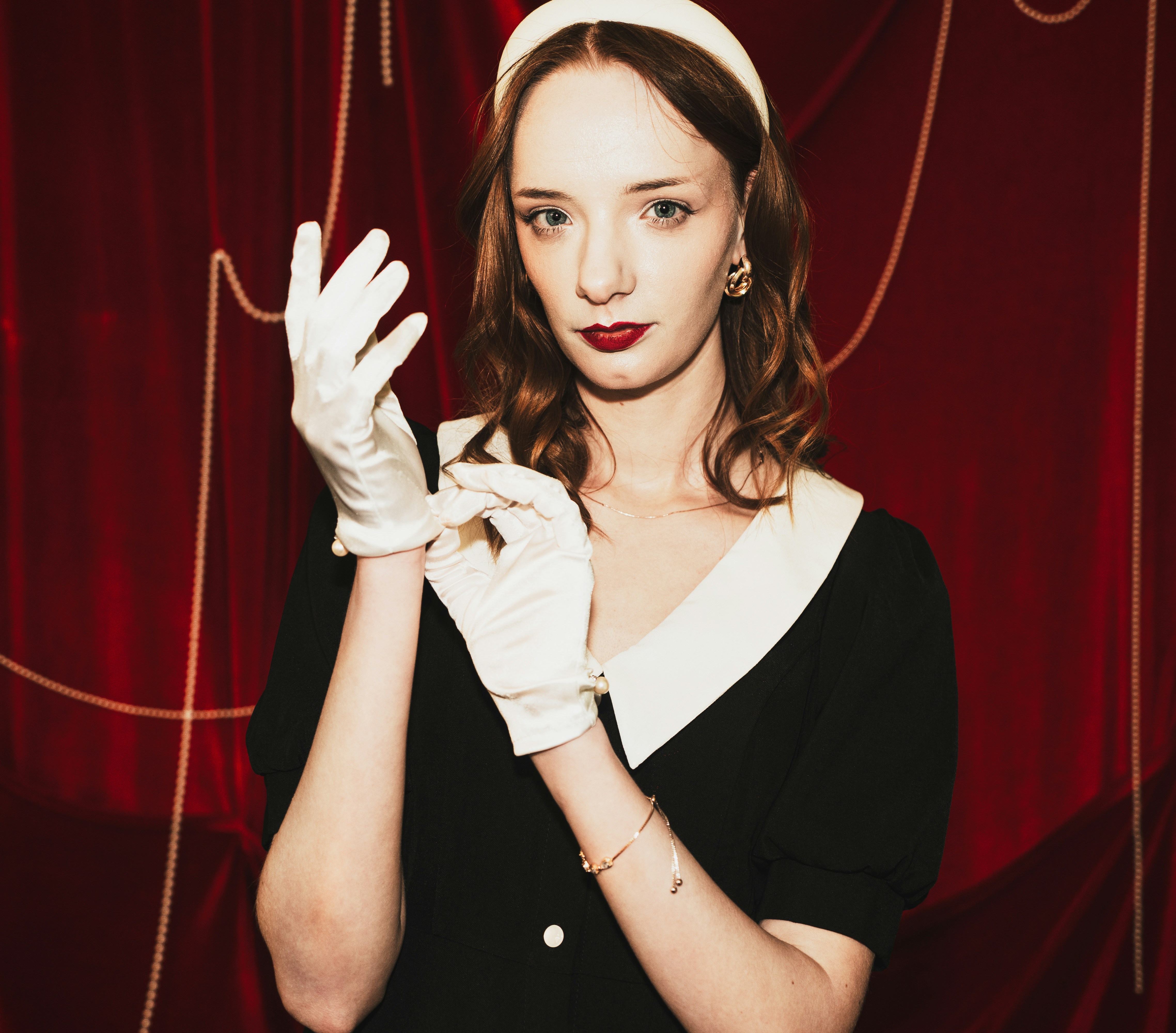 Woman in vintage dress and gloves adjusts her hand