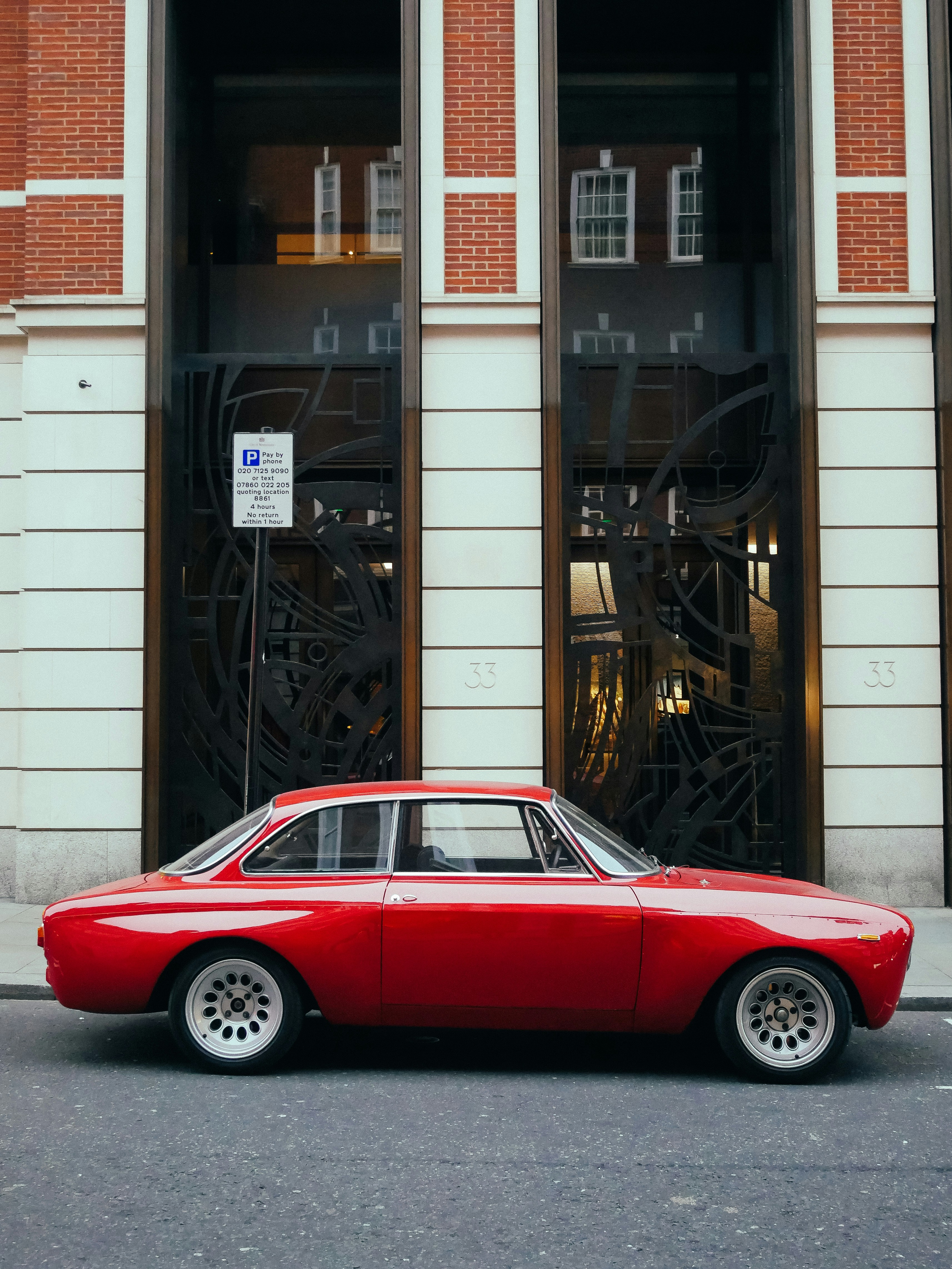 Un'auto d'epoca rossa parcheggiata in una strada cittadina.