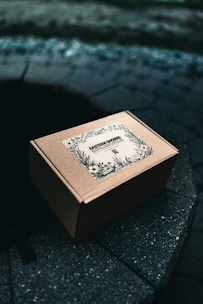 Cardboard box with floral label on stone surface