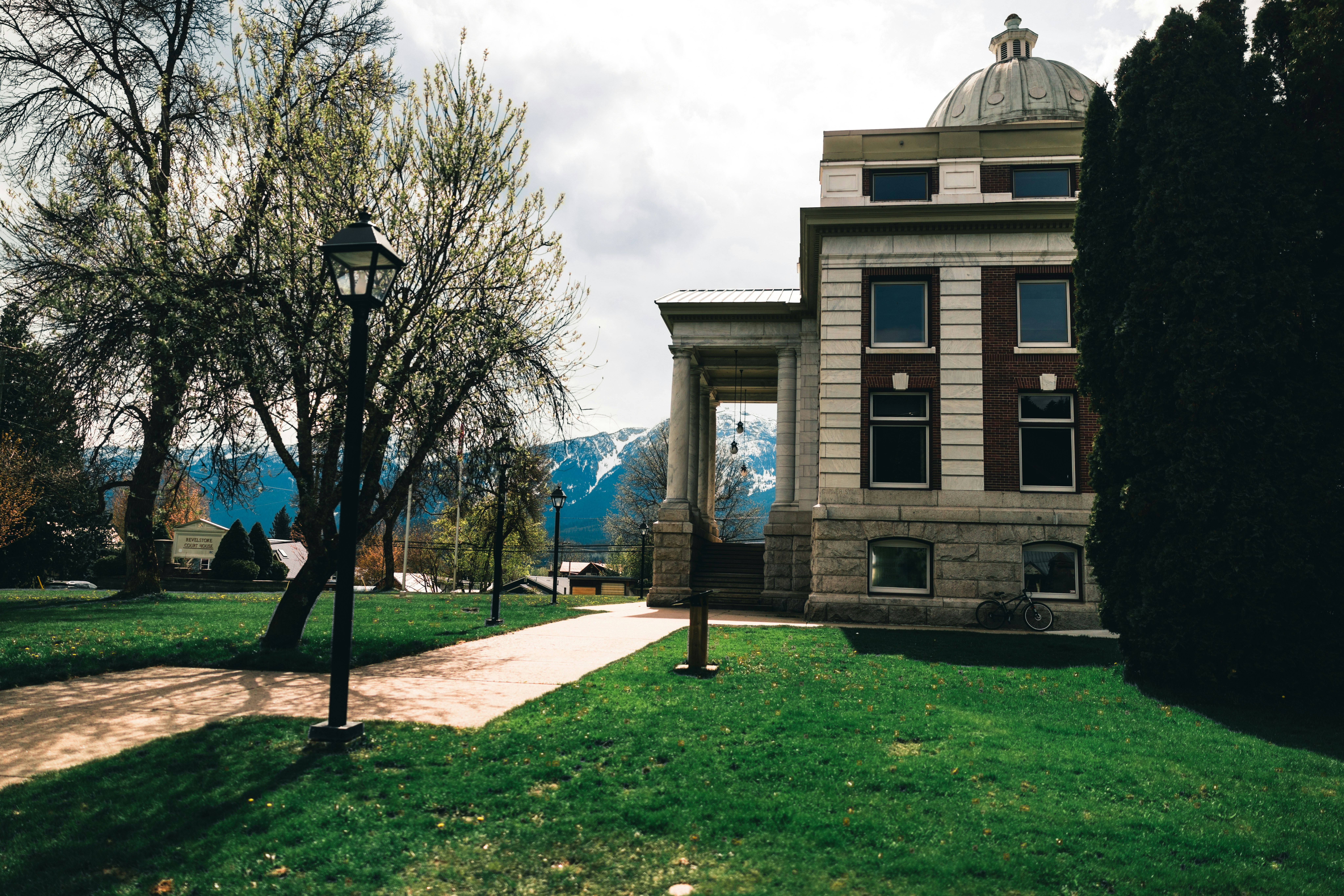 Historic building with dome and columns on grassy lawn.