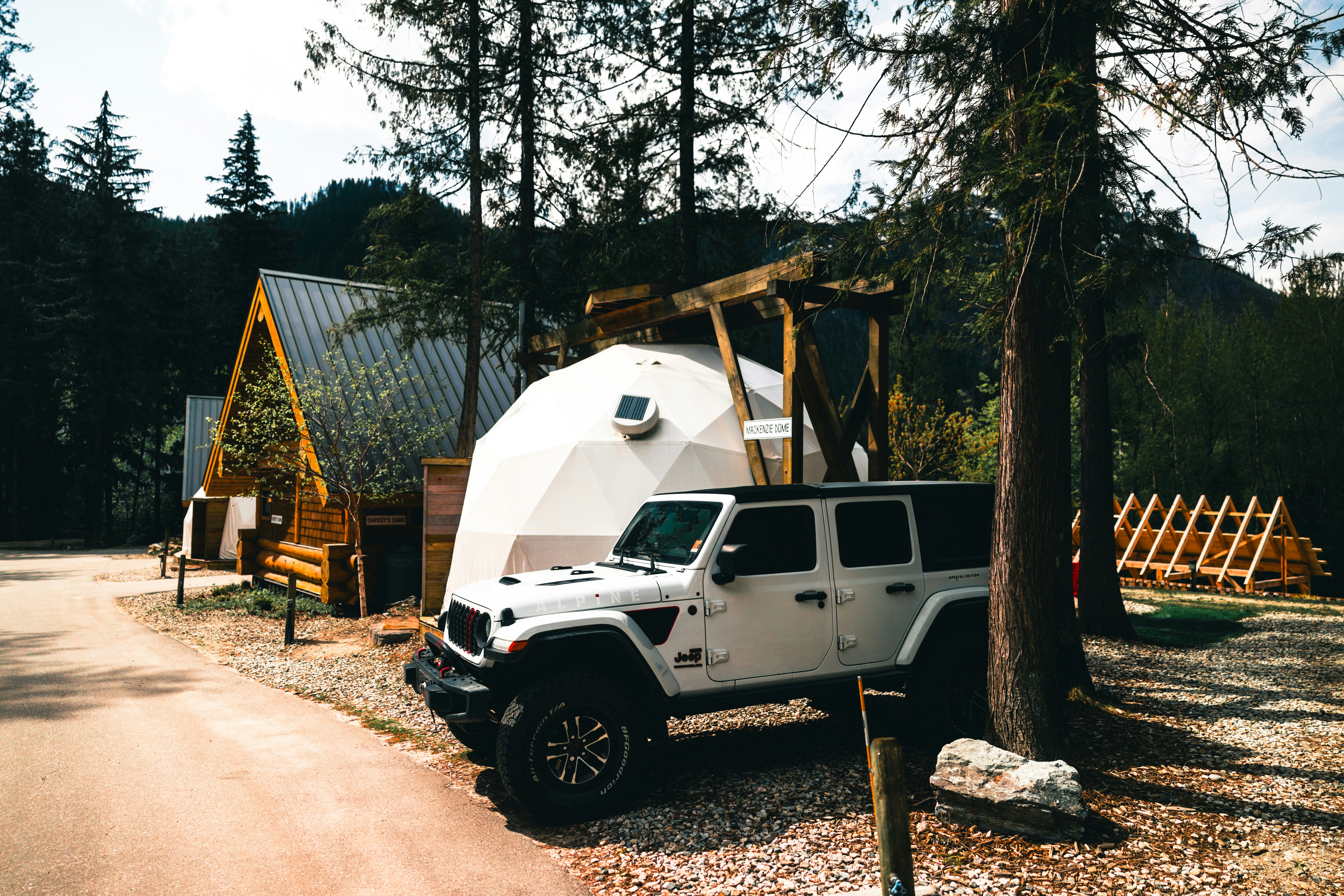 Jeep bianca parcheggiata accanto a una cupola geodetica e cabine