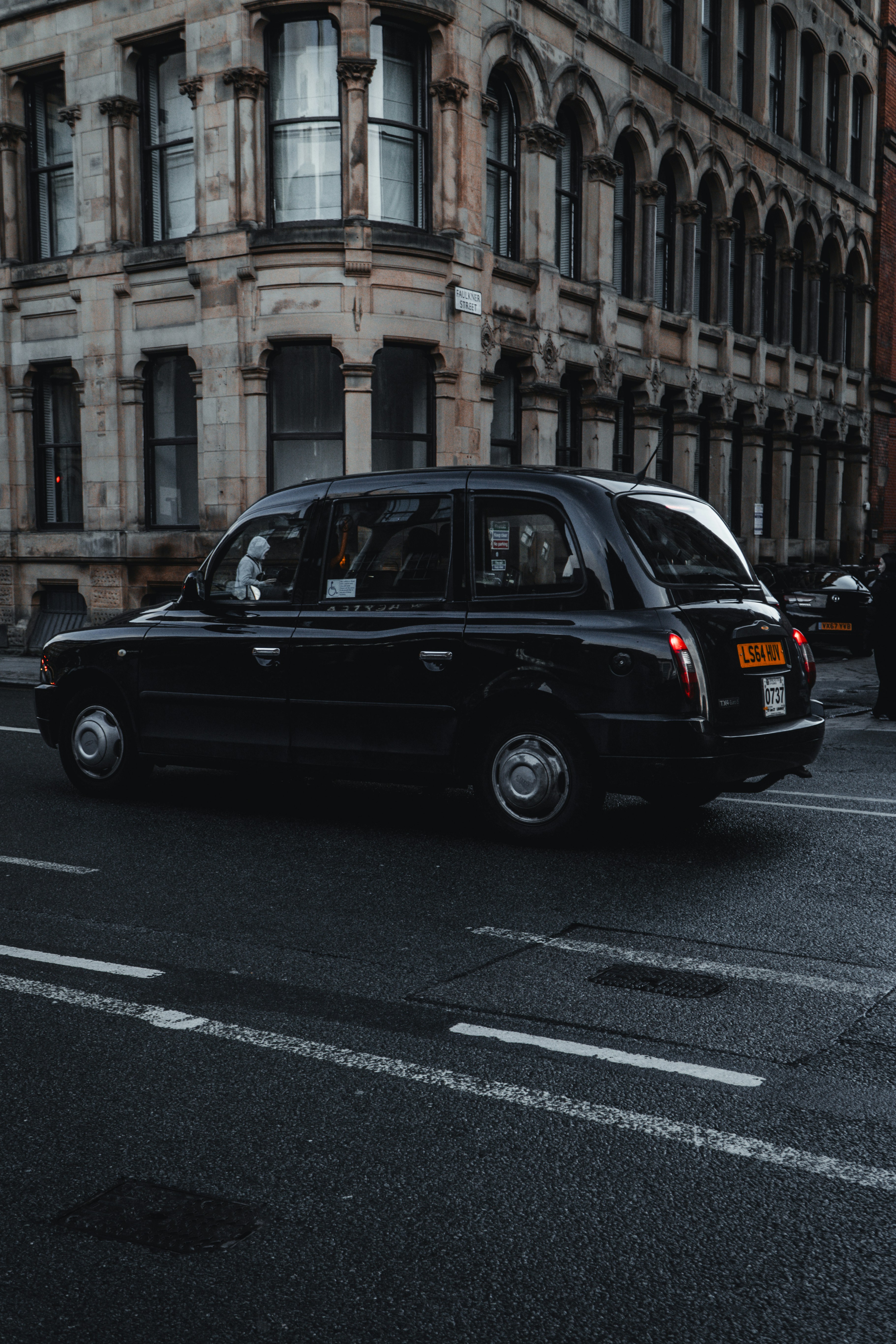 Un taxi nero percorre una strada cittadina.