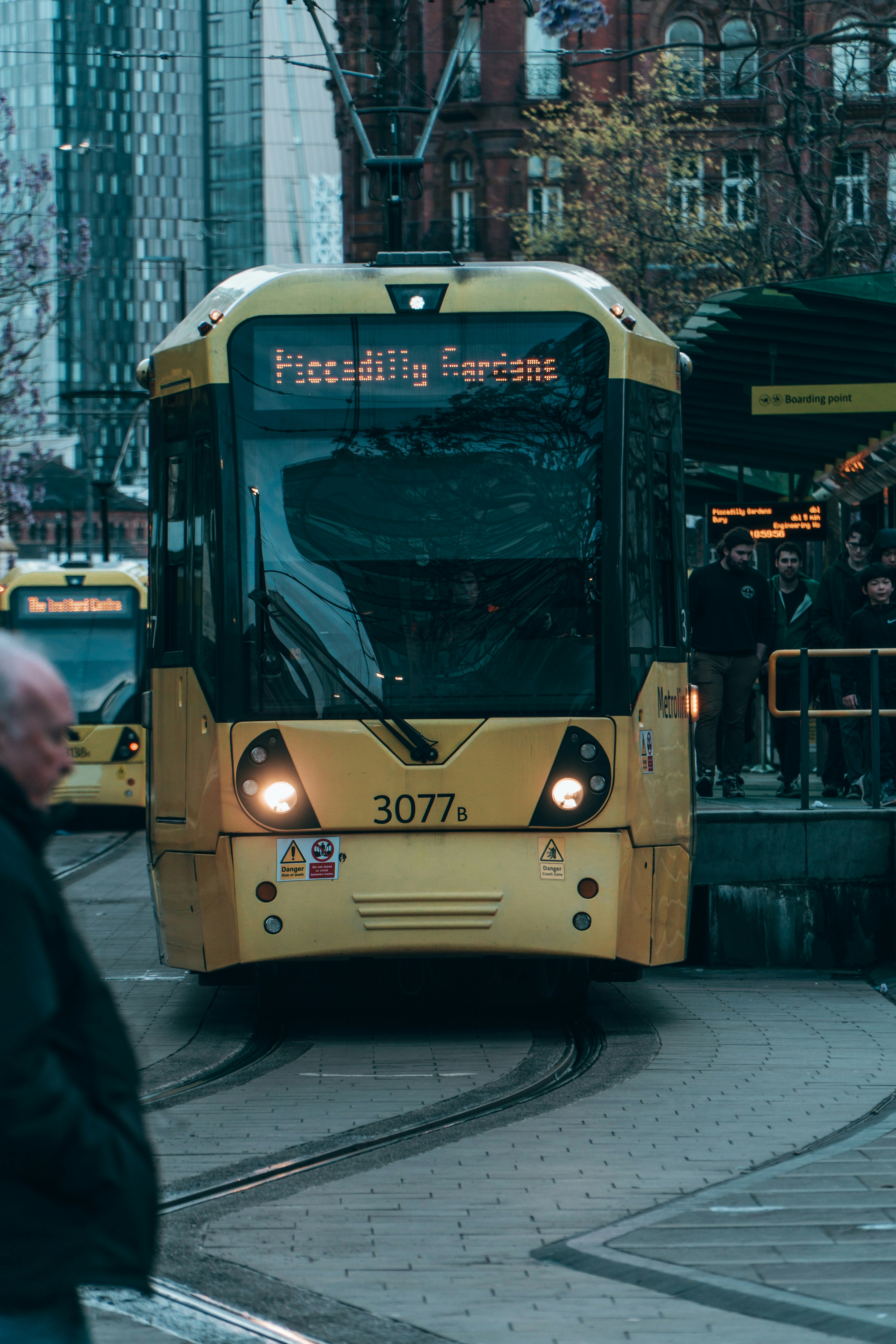 Un tram giallo arriva a una banchina della stazione.
