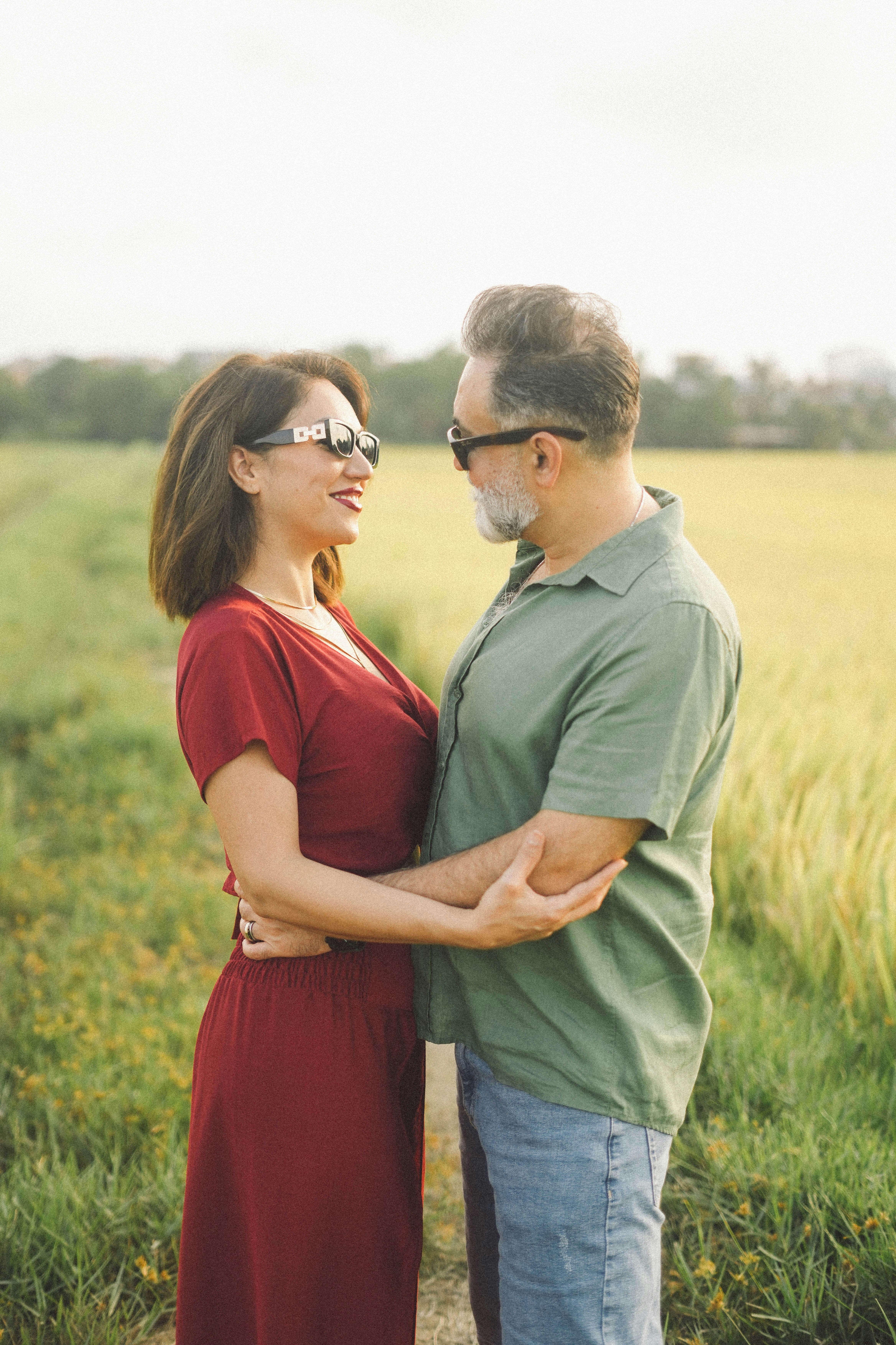 Pareja abrazándose en un campo al atardecer