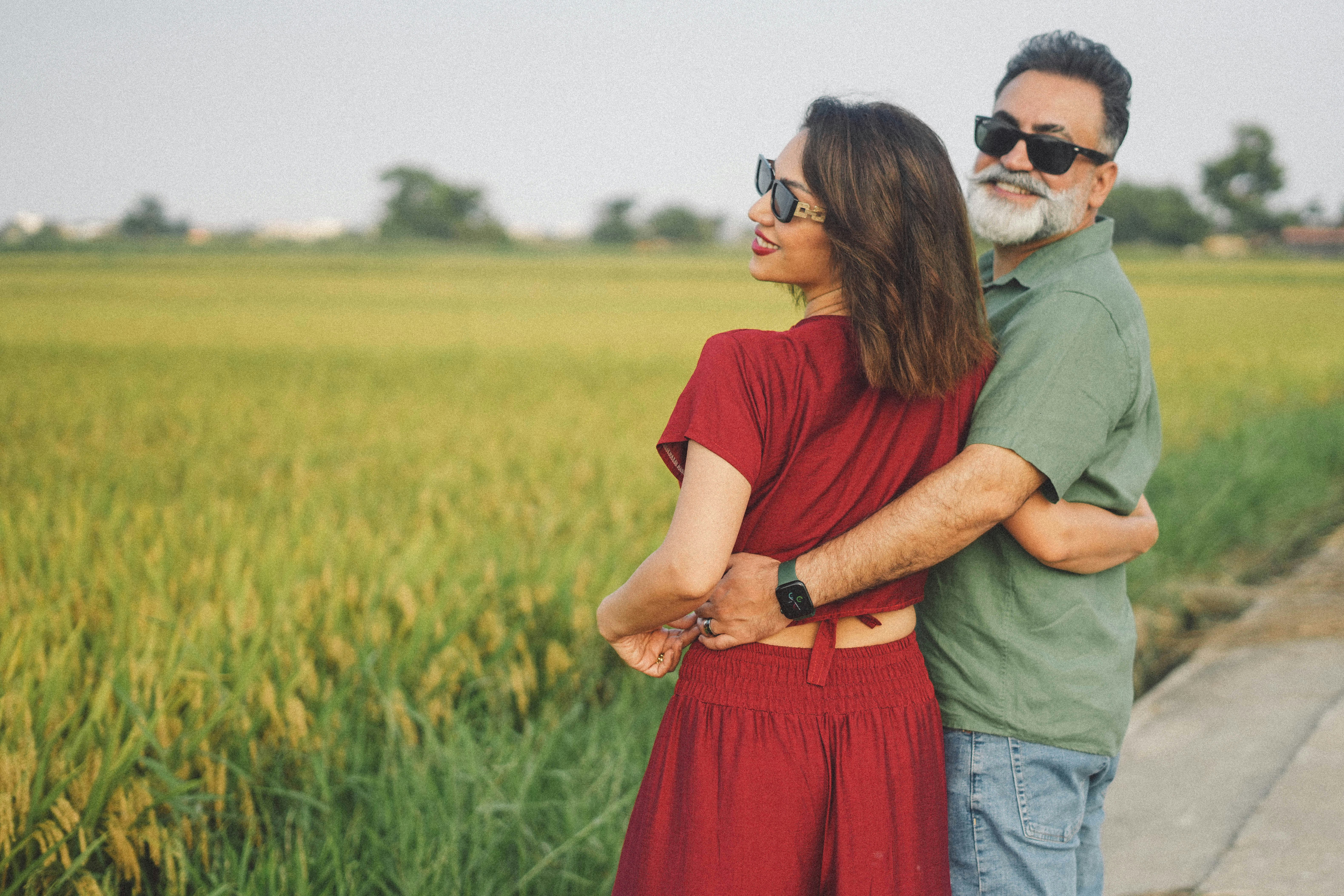 Couple embracing in a field at sunset