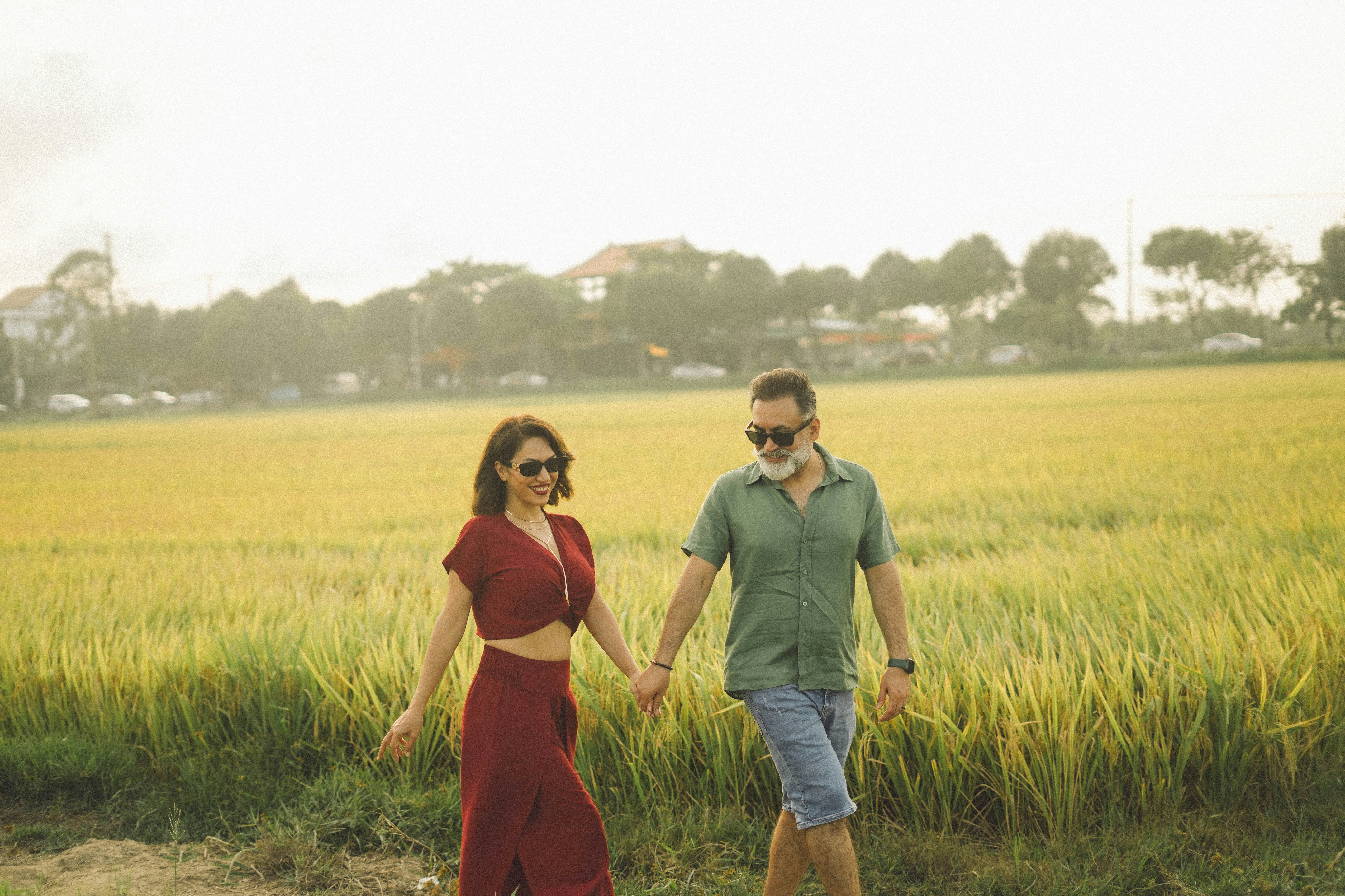 Pareja caminando de la mano por un campo