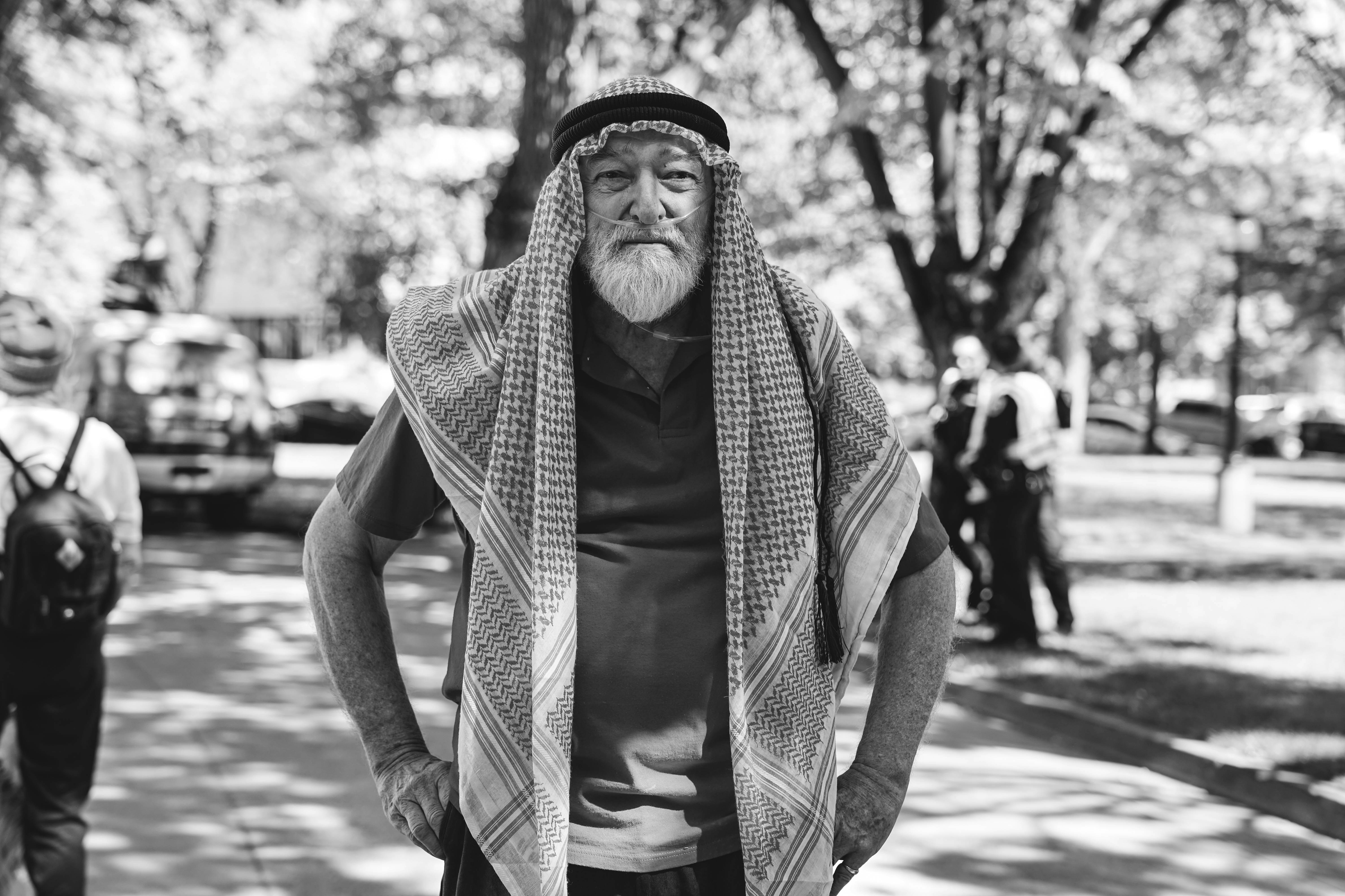 Elderly man in traditional headwear and scarf outdoors