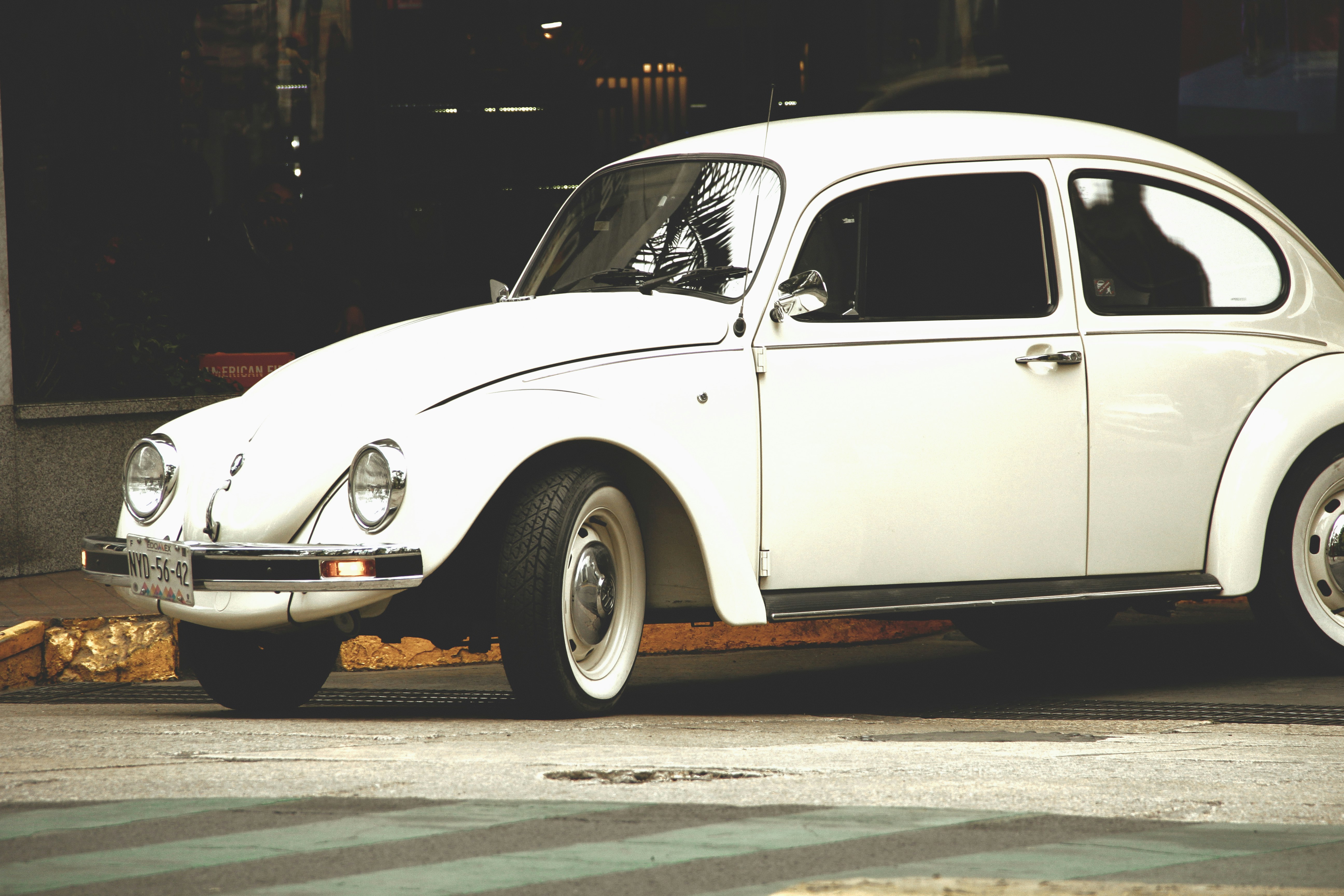 Une Volkswagen Coccinelle blanche classique garée dehors.