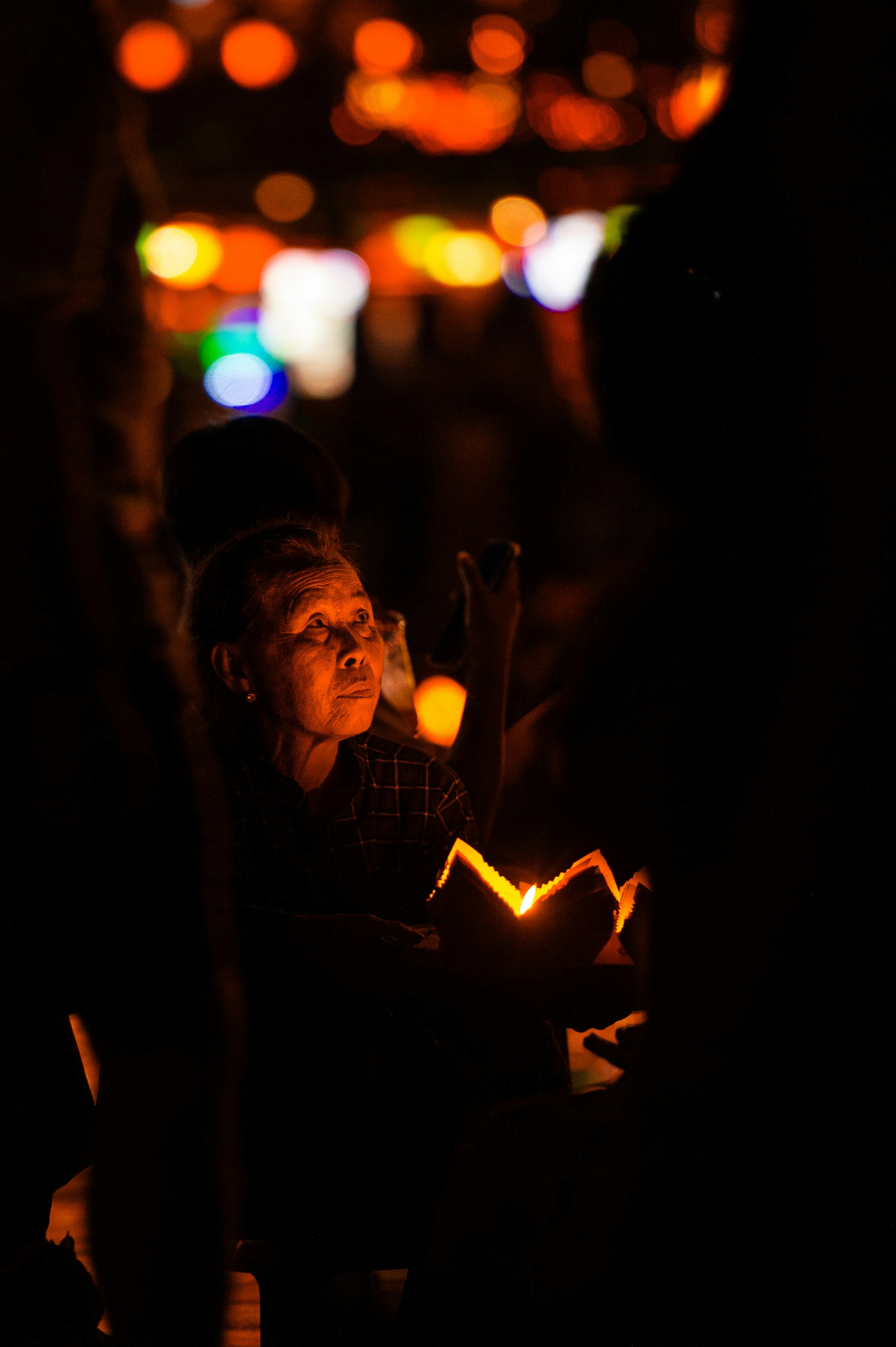 Senhora idosa segurando uma lanterna brilhante à noite