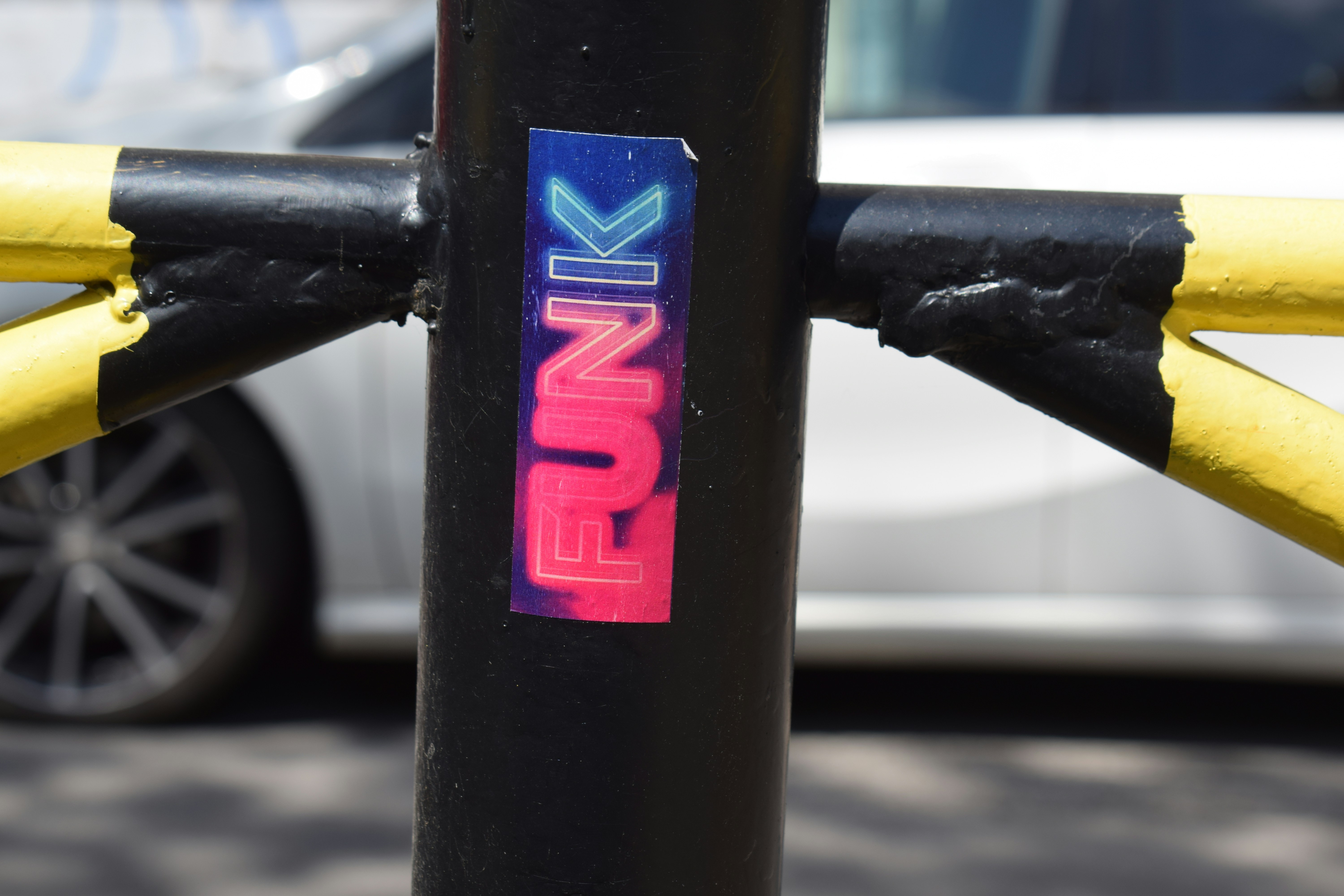 A sticker with the word funk on a black pole.
