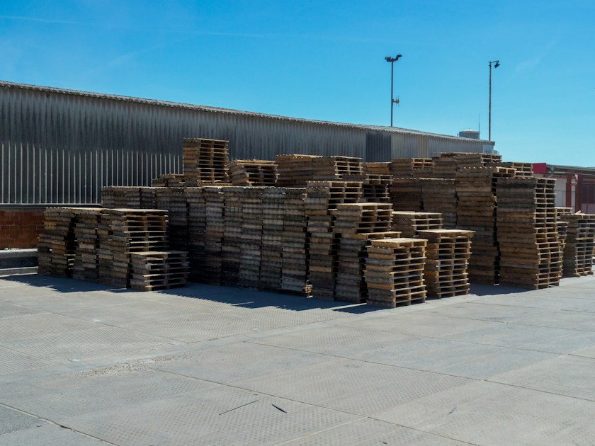 Stacks of wooden pallets outside a warehouse