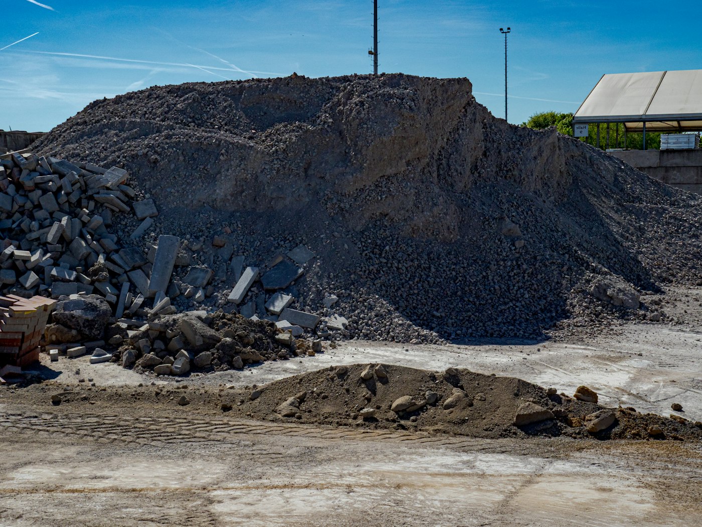 Sorted piles of crushed concrete and rubble at a recycling yard