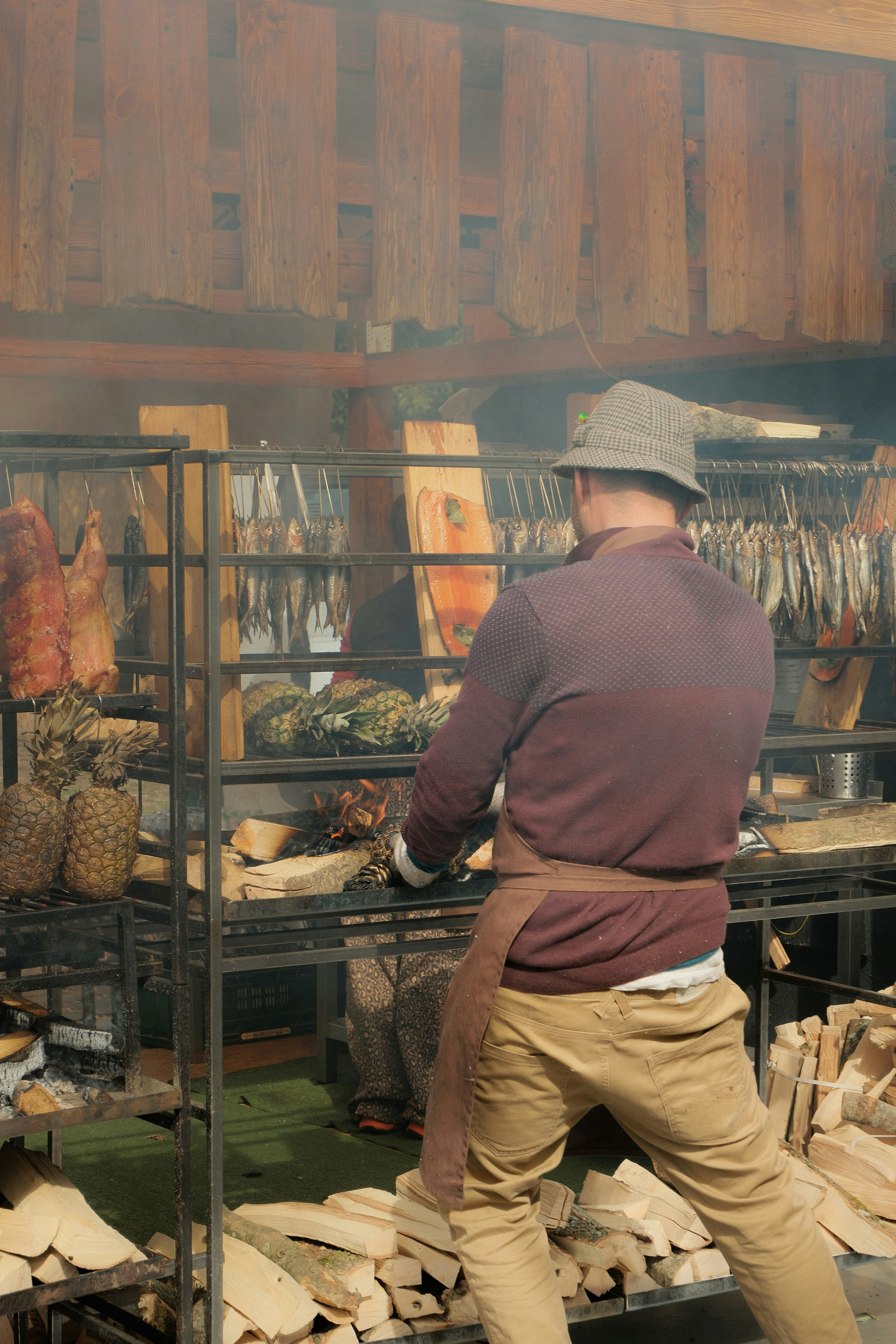 Man smoking fish and meat in a rustic smokehouse