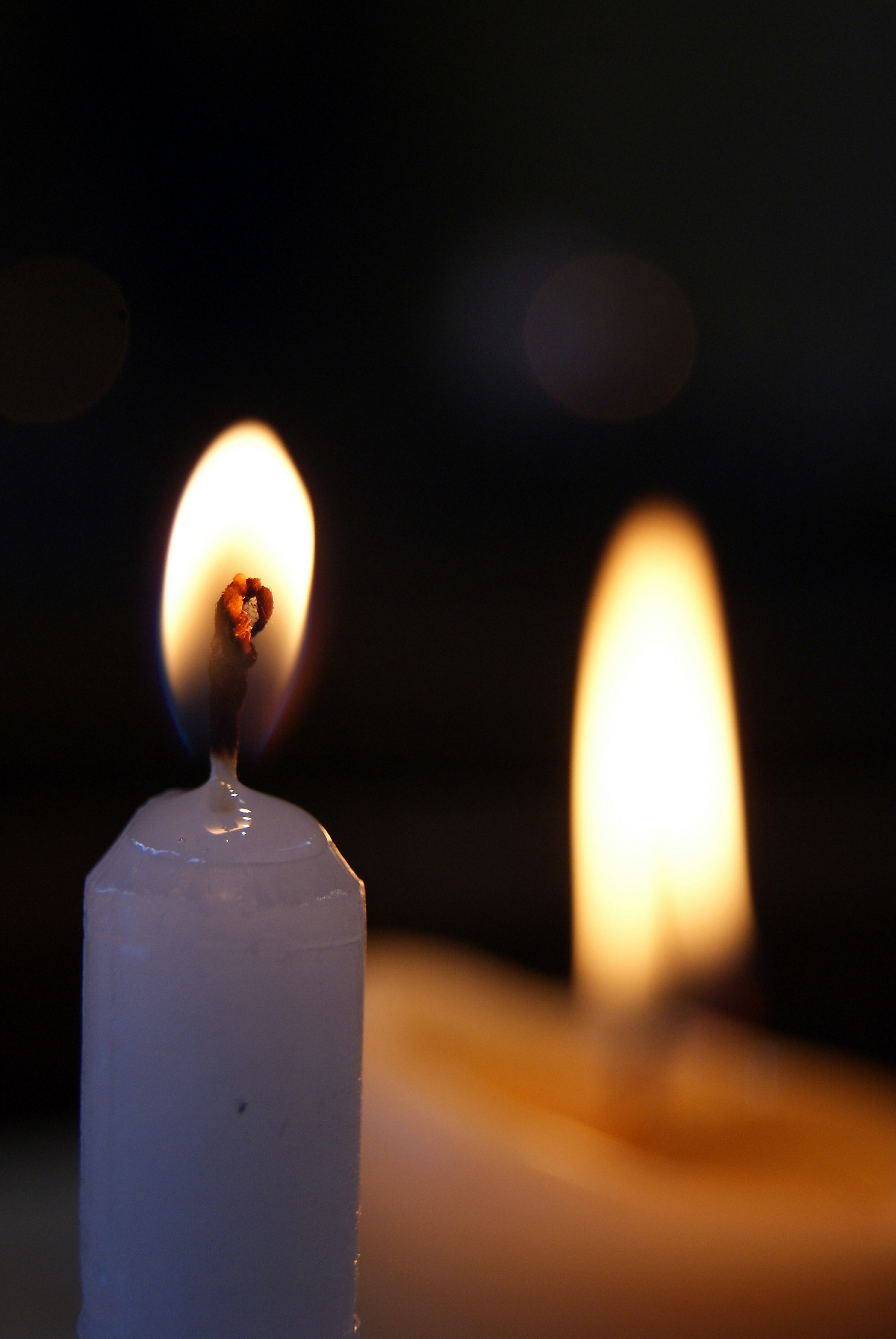 Two lit candles with dark background
