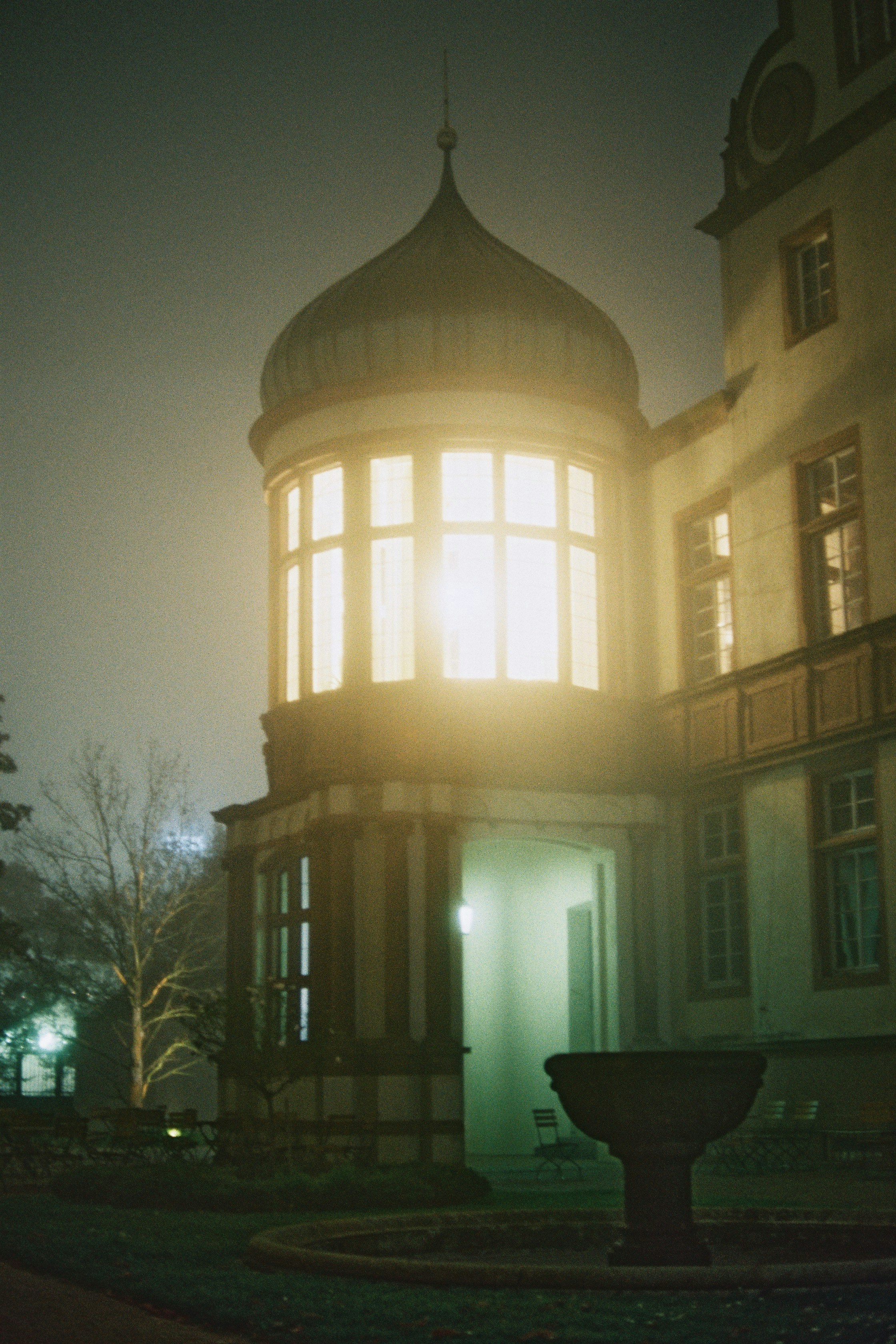 Burgturm nachts vom Nebel erleuchtet