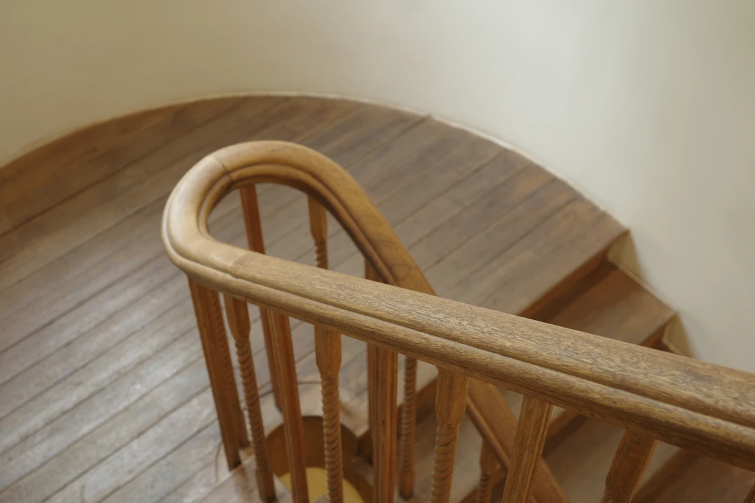 Anti-Slip Stair Treads — Wooden staircase with a curved handrail
