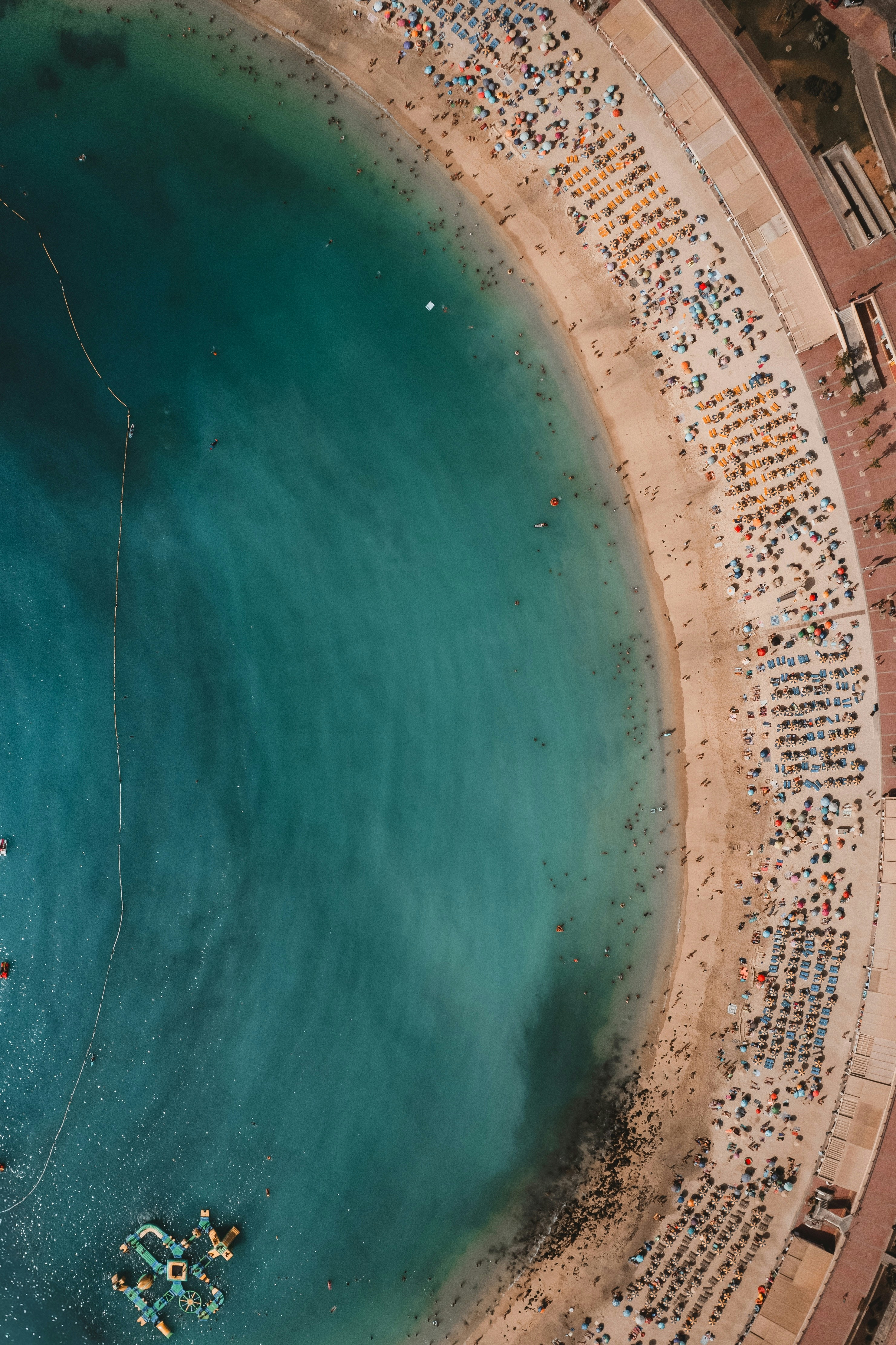 Aerial view of a crowded beach with turquoise water.