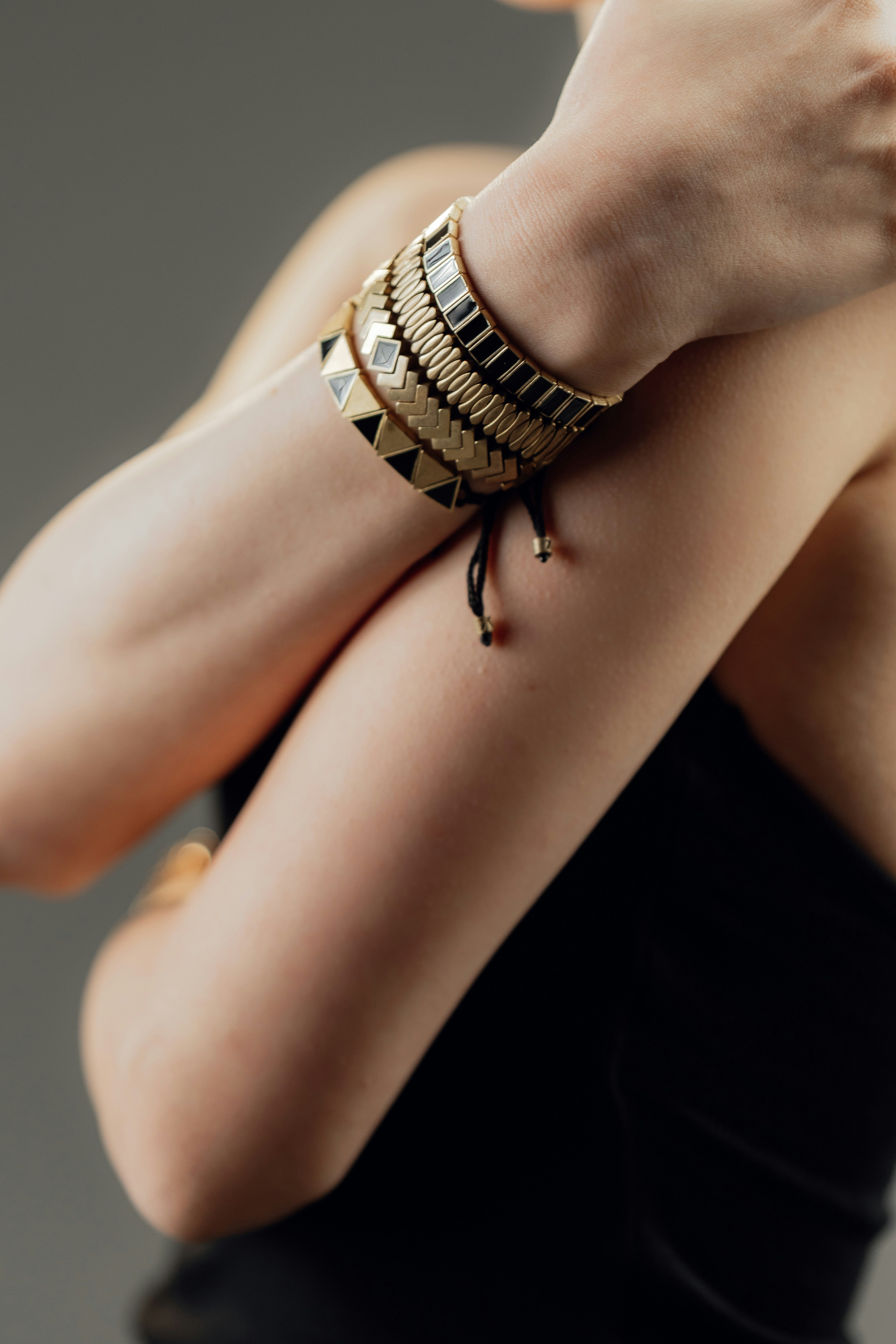 Woman wearing stacked gold and black bracelets