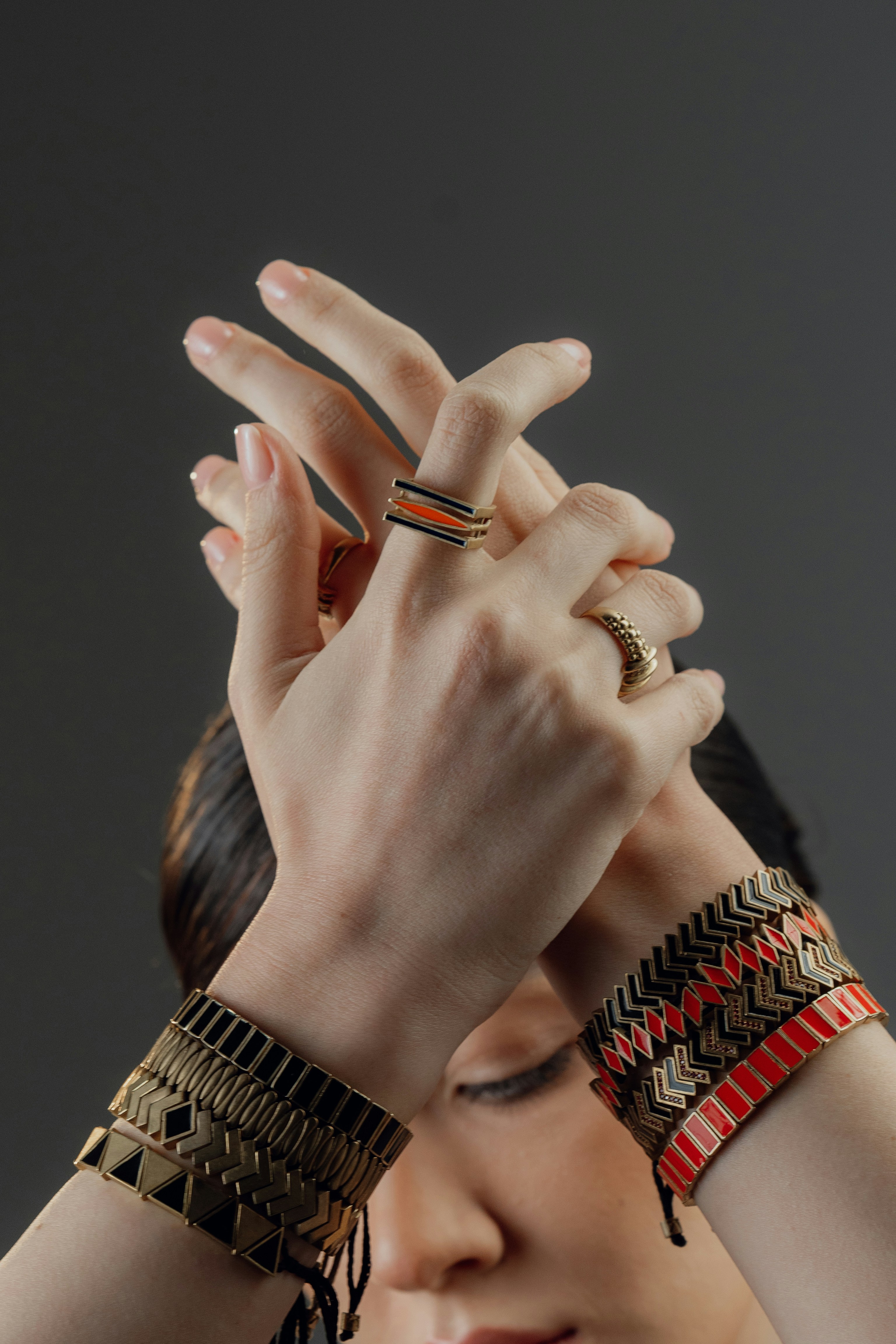 Woman wearing bracelets and rings with crossed hands