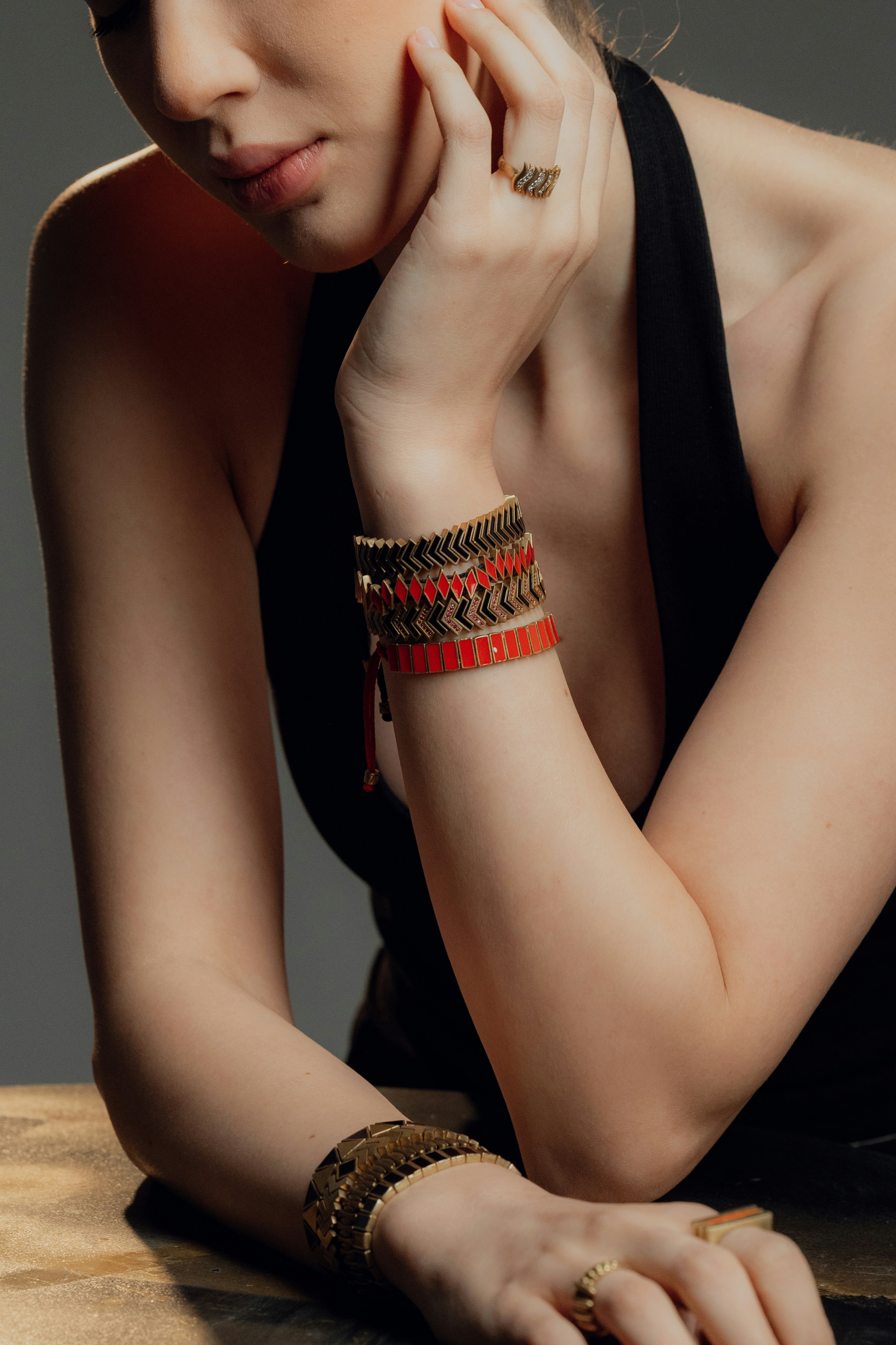 Woman wearing layered bracelets and rings