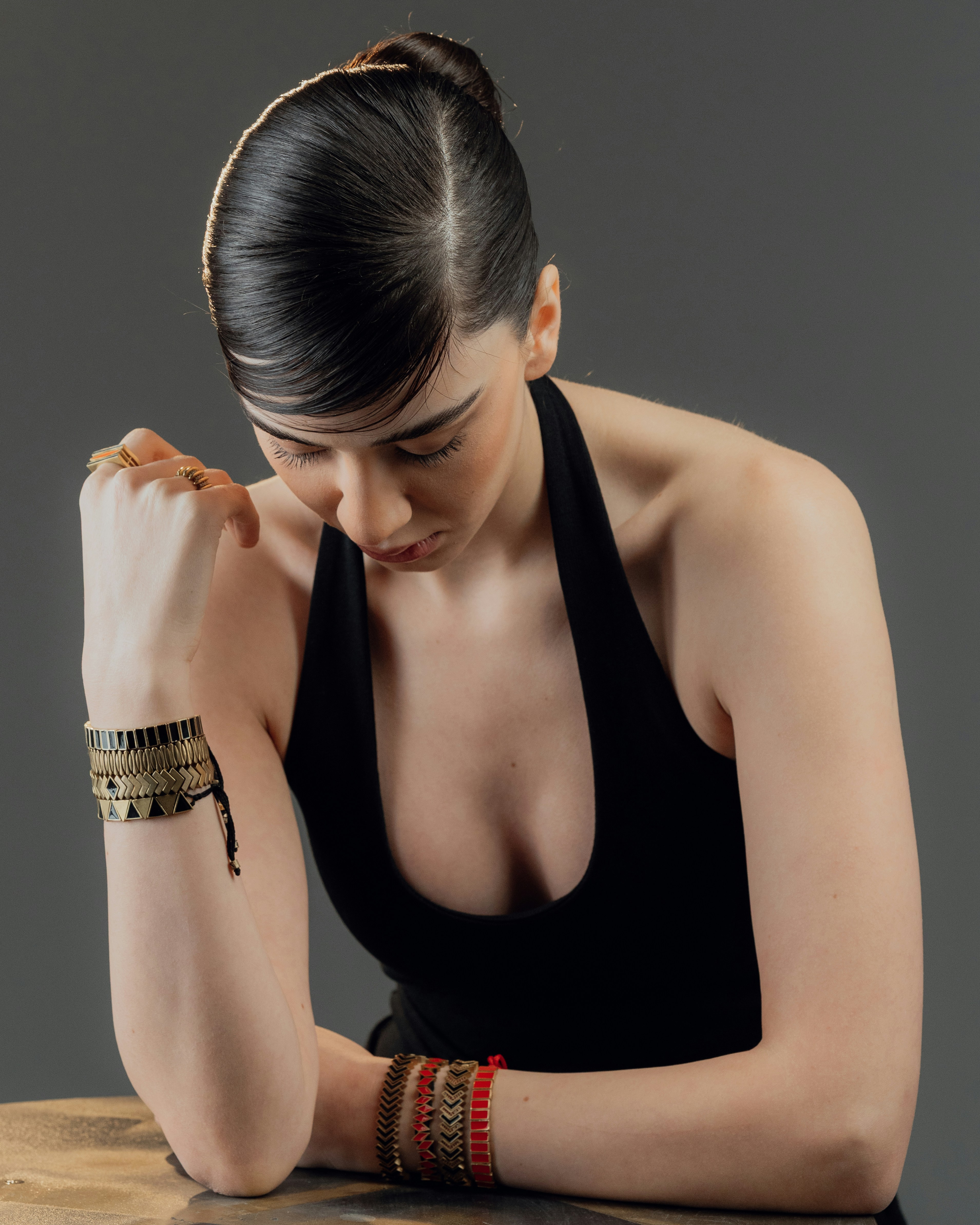 A woman with bracelets leans forward