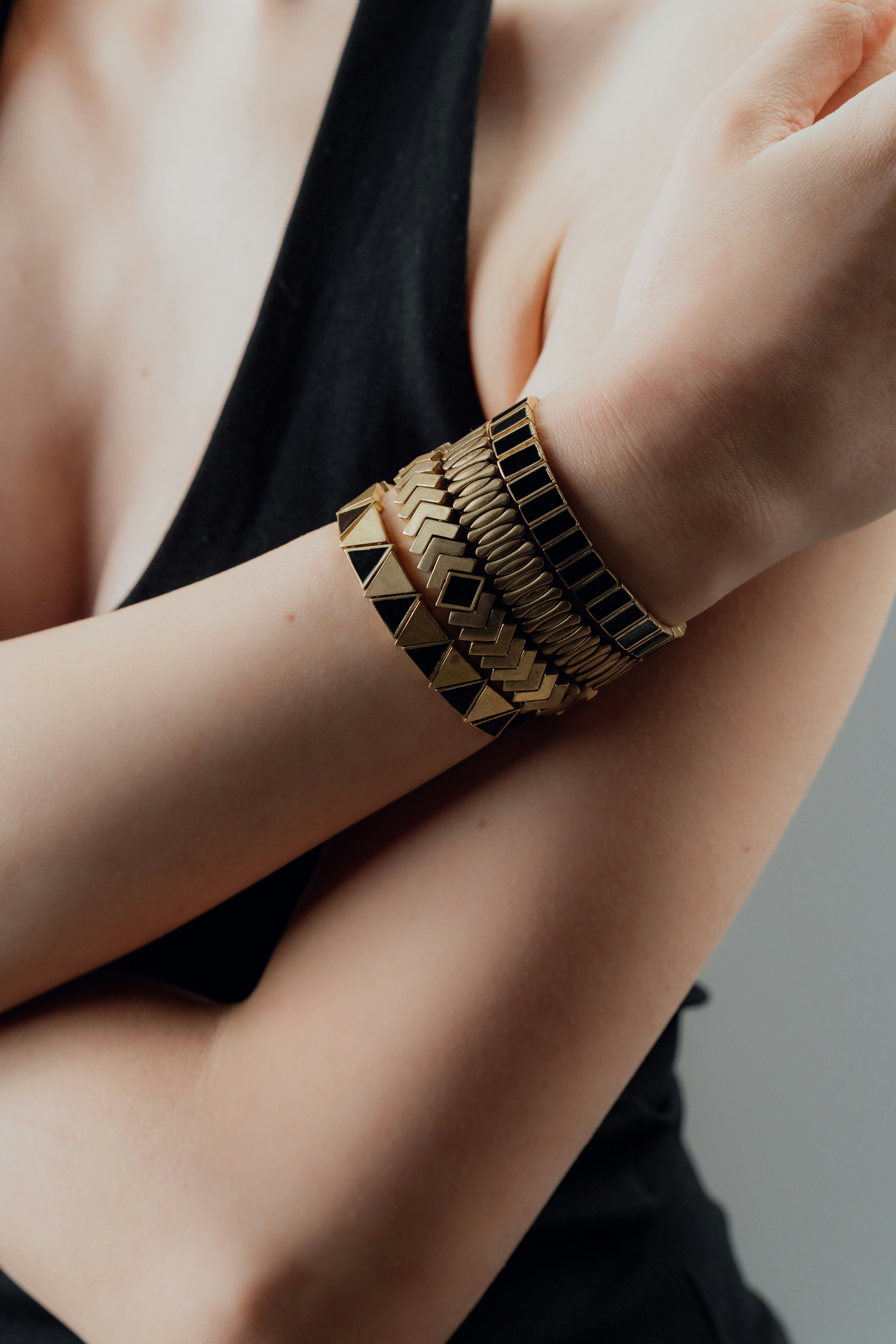 Woman wearing stacked gold and black bracelets