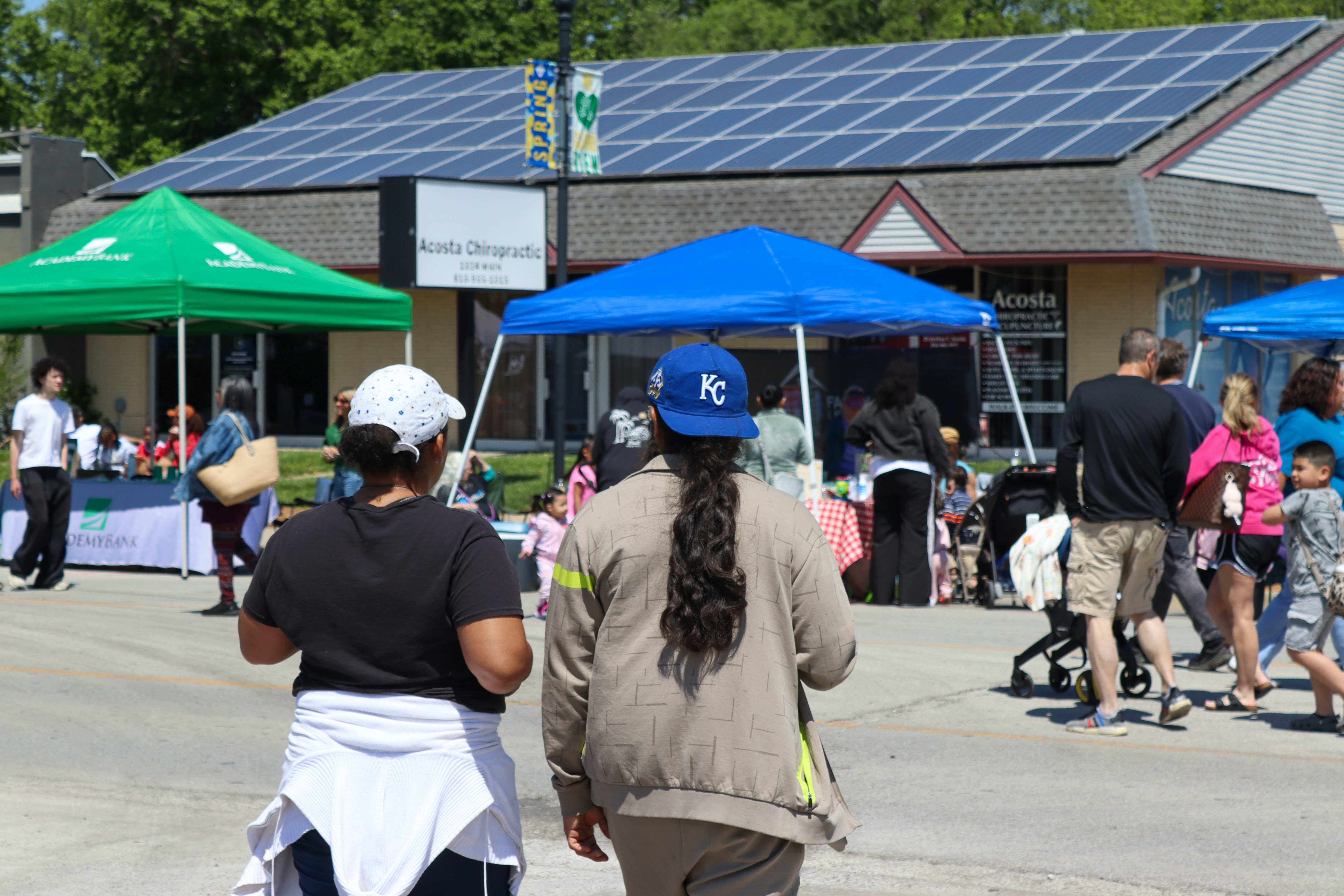 People at an outdoor market with solar panels on roof.