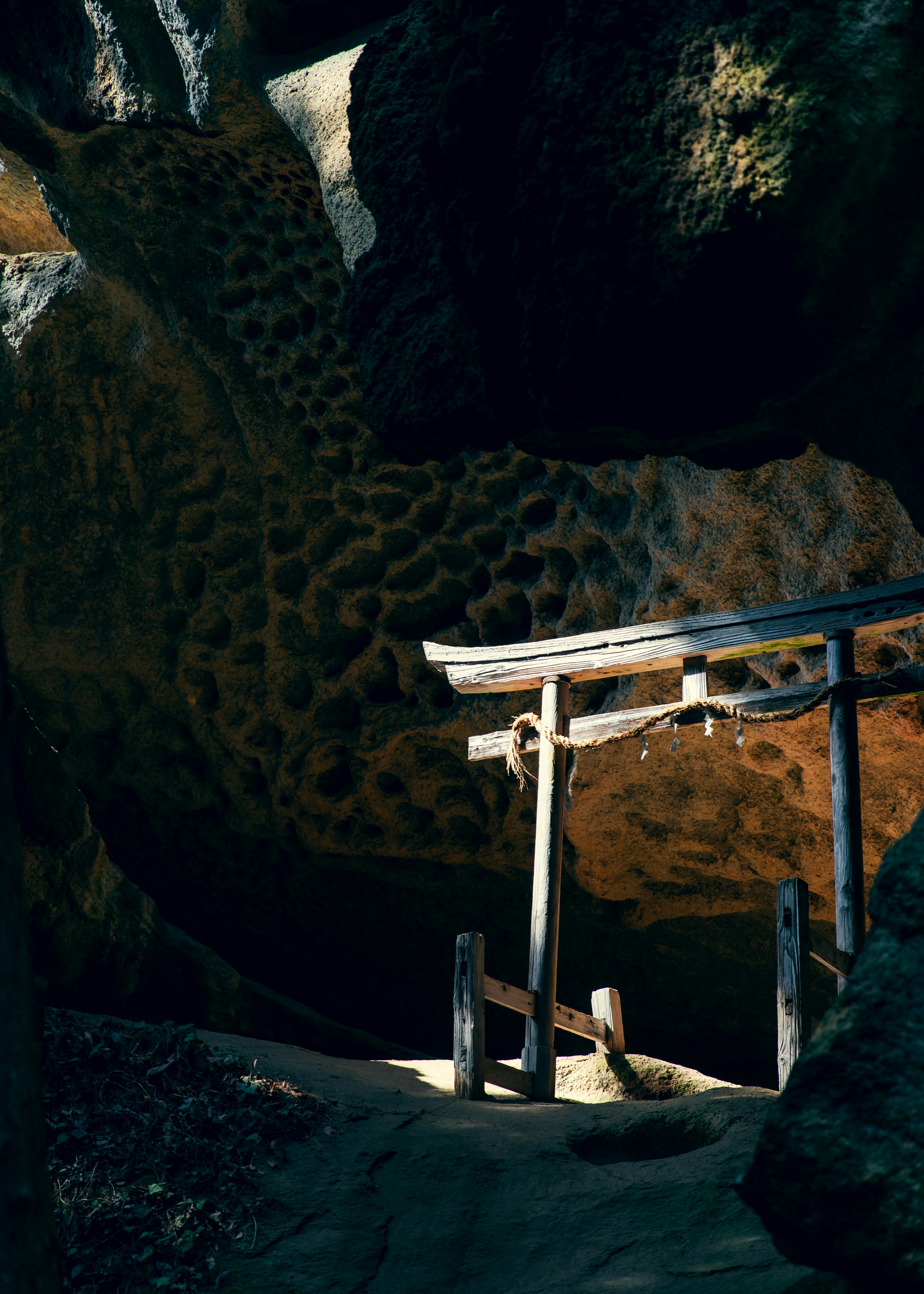 Wooden torii gate in a rocky cave entrance
