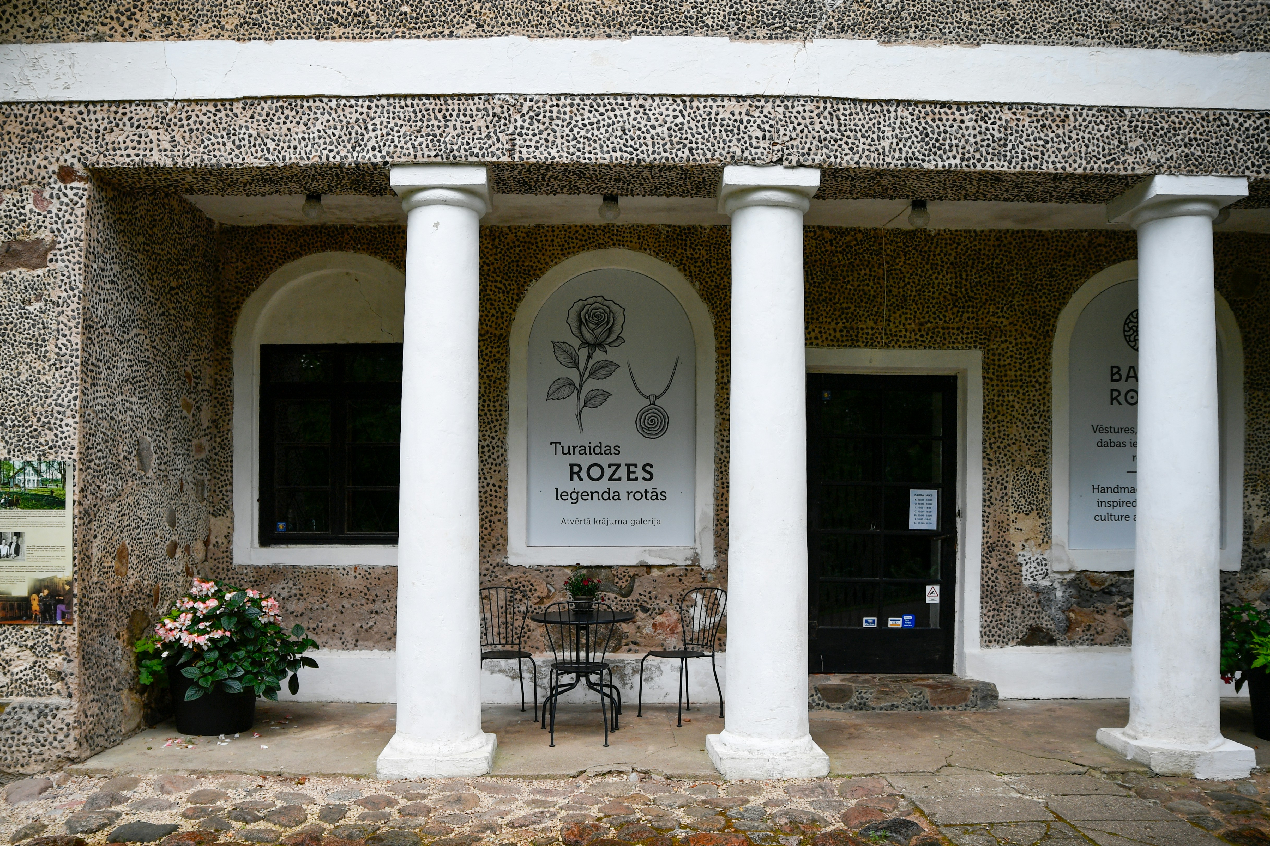 Entrée du bâtiment avec colonnes blanches et plantes en pot