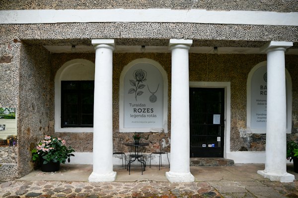 Building entrance with white columns and potted plants — Sigulda, Latvia