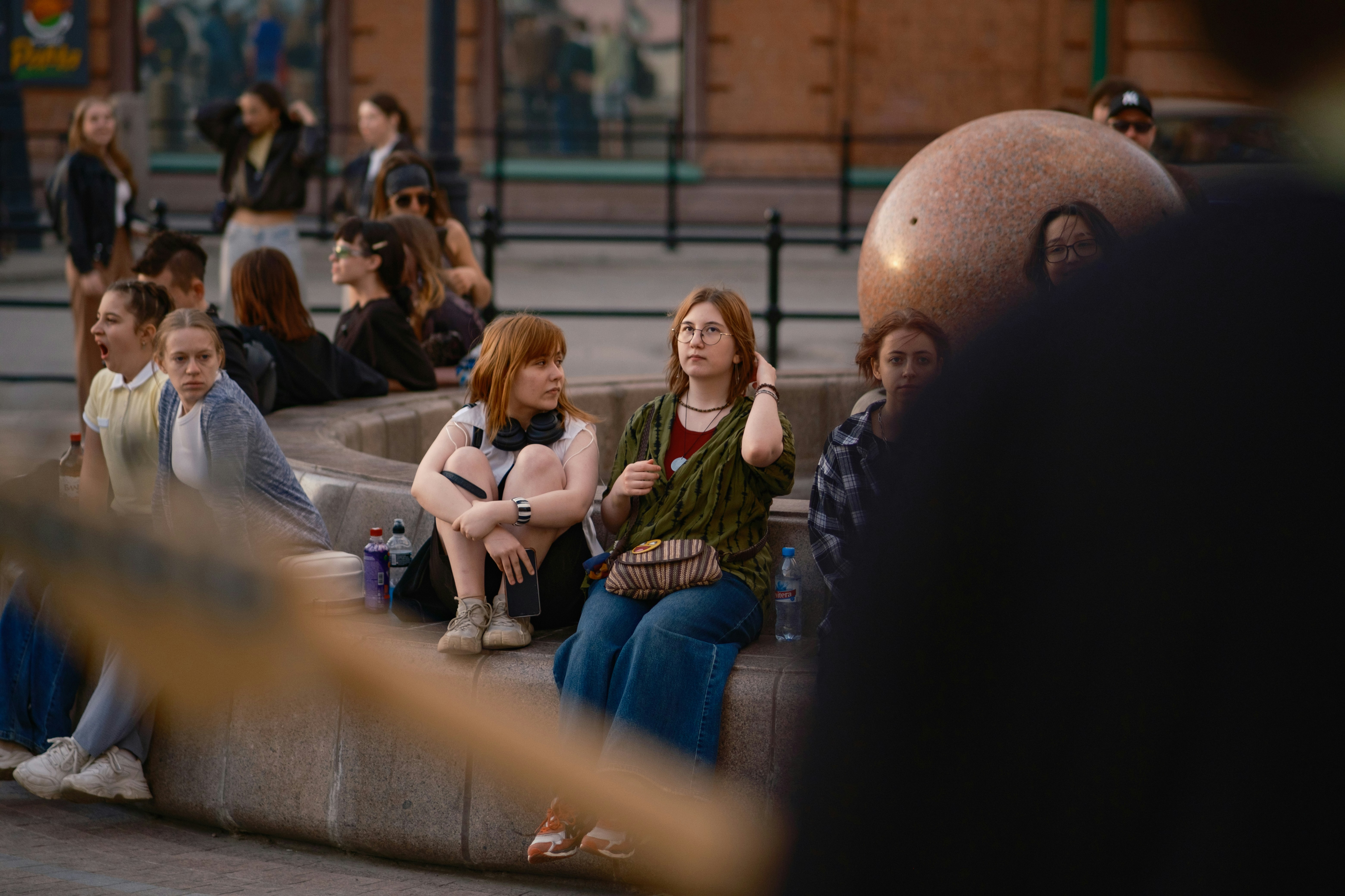 People sitting on a stone structure outdoors