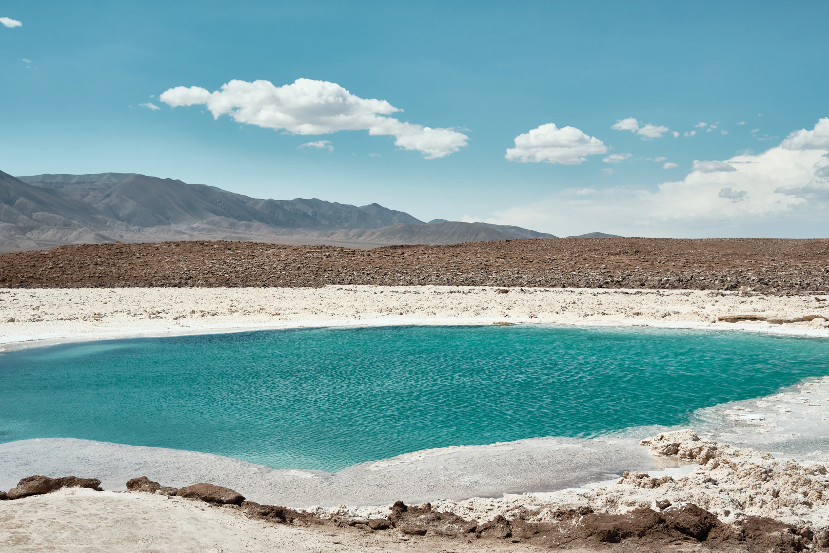 A turquoise salt lagoon surrounded by the Atacama Desert in Chile