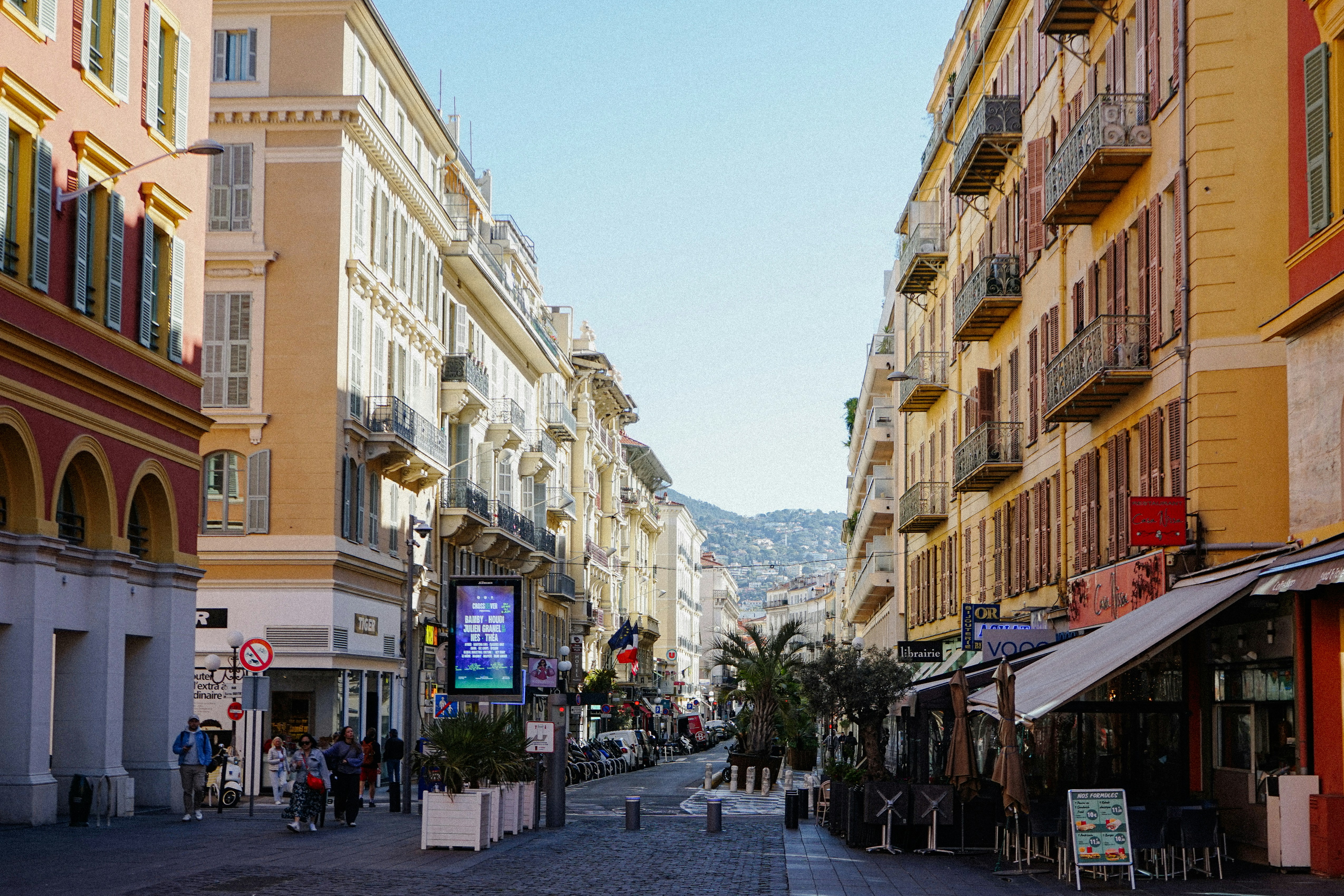 A sunny street lined with buildings and shops.