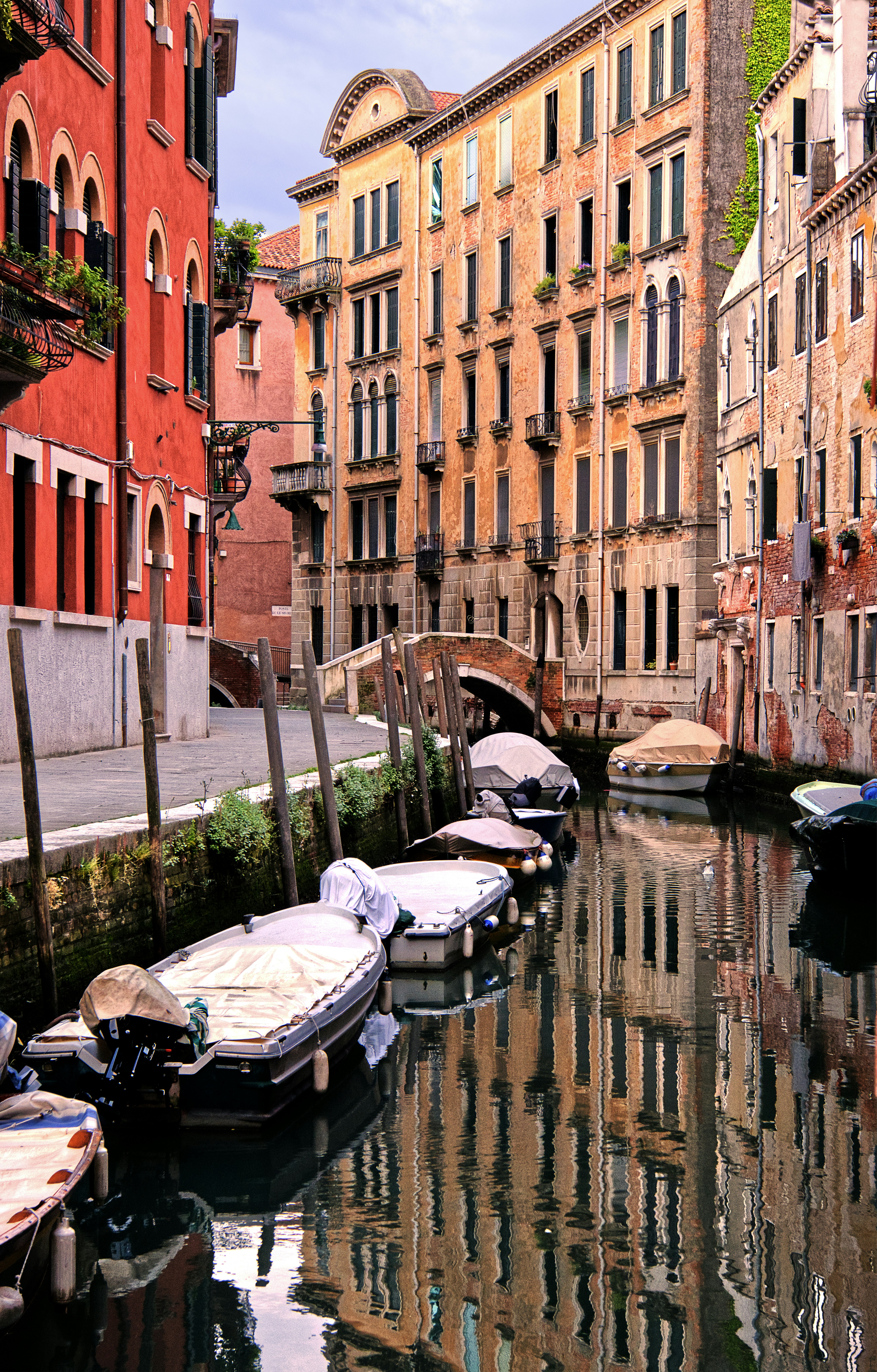 Des bateaux accostaient le long d’un canal à Venise avec des bâtiments historiques.