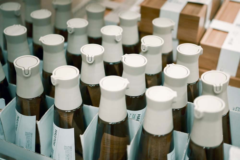 A full case of identical amber supplement bottles with white caps