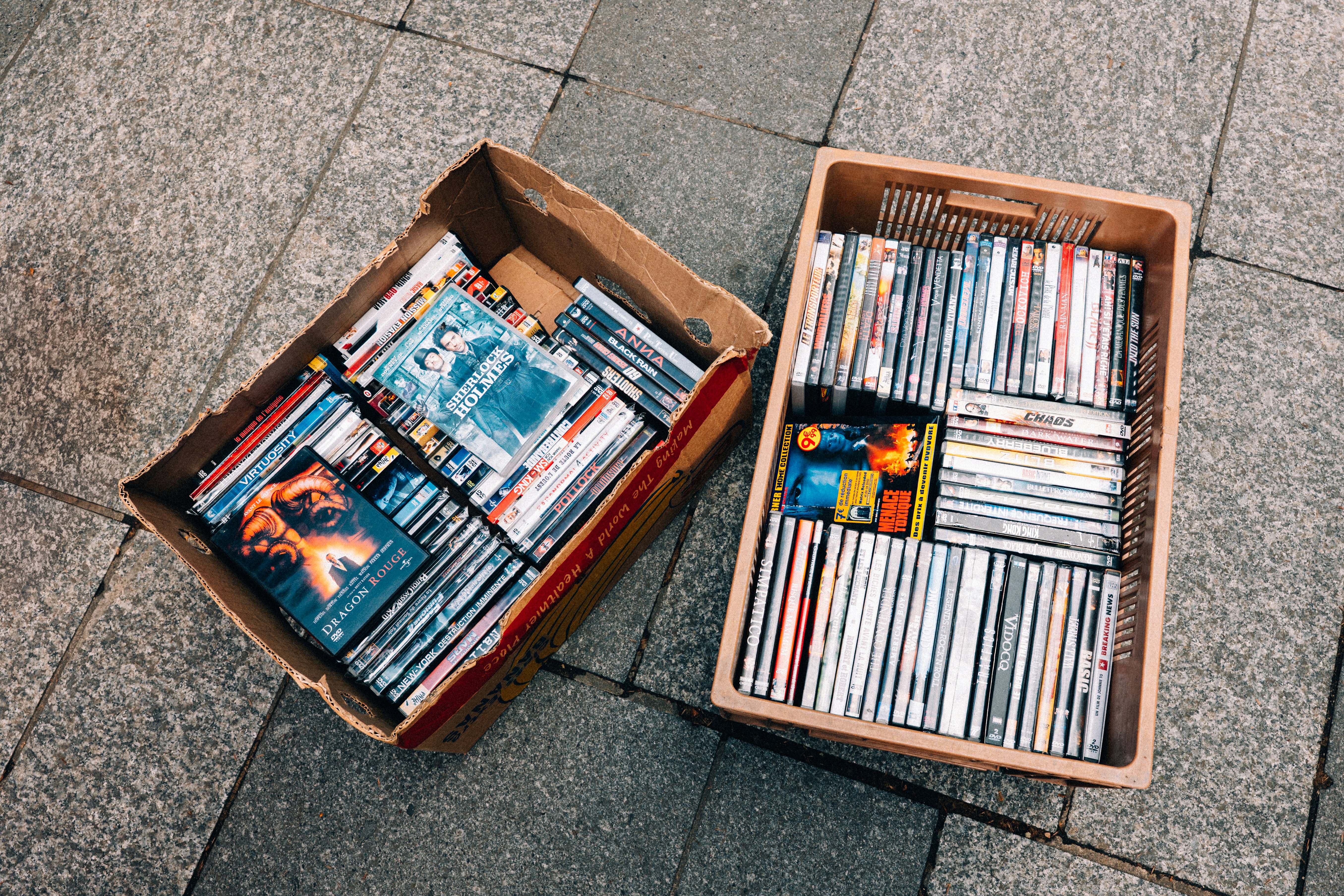 Deux cartons remplis de CD sur un trottoir