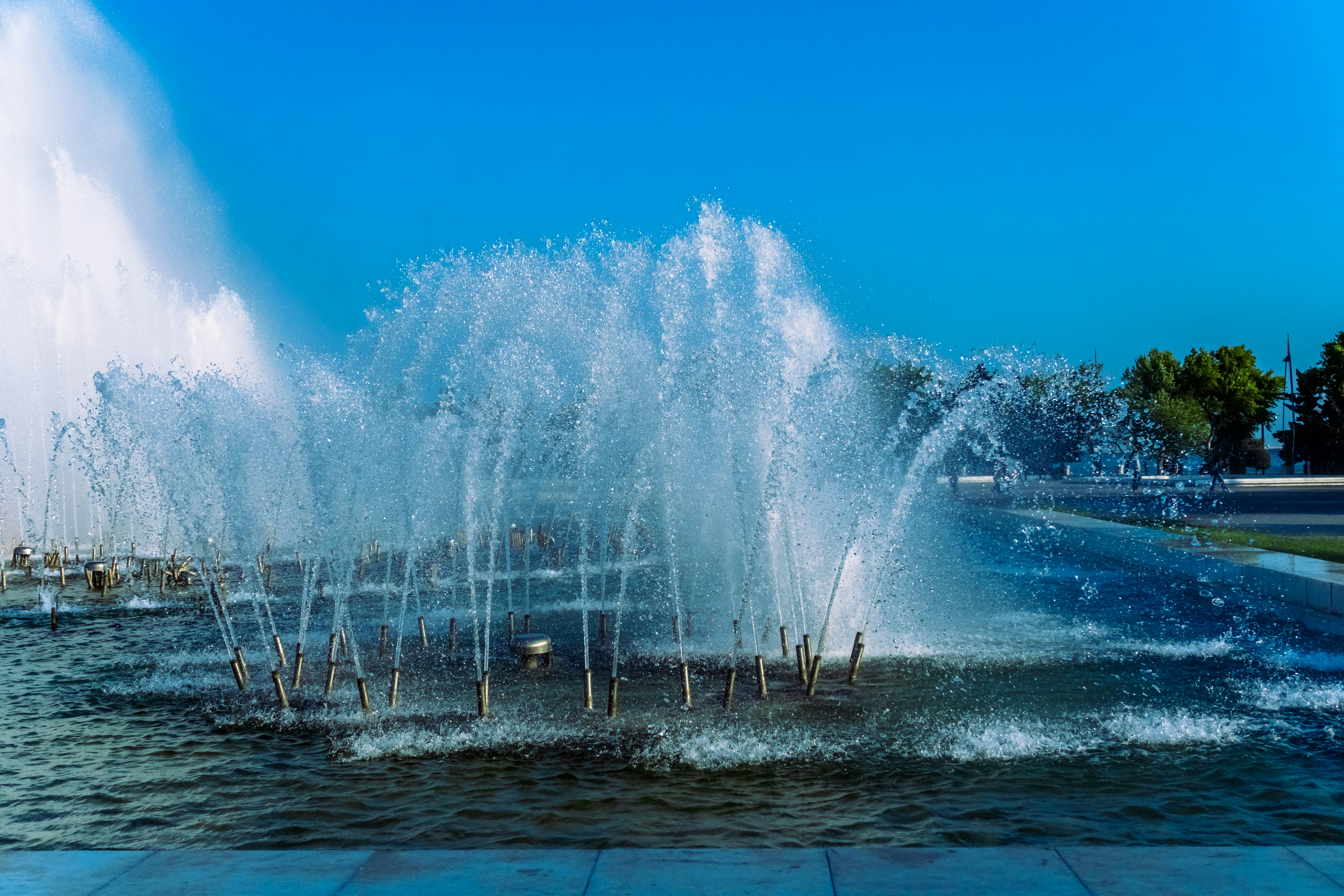 A large fountain spraying water against a blue sky