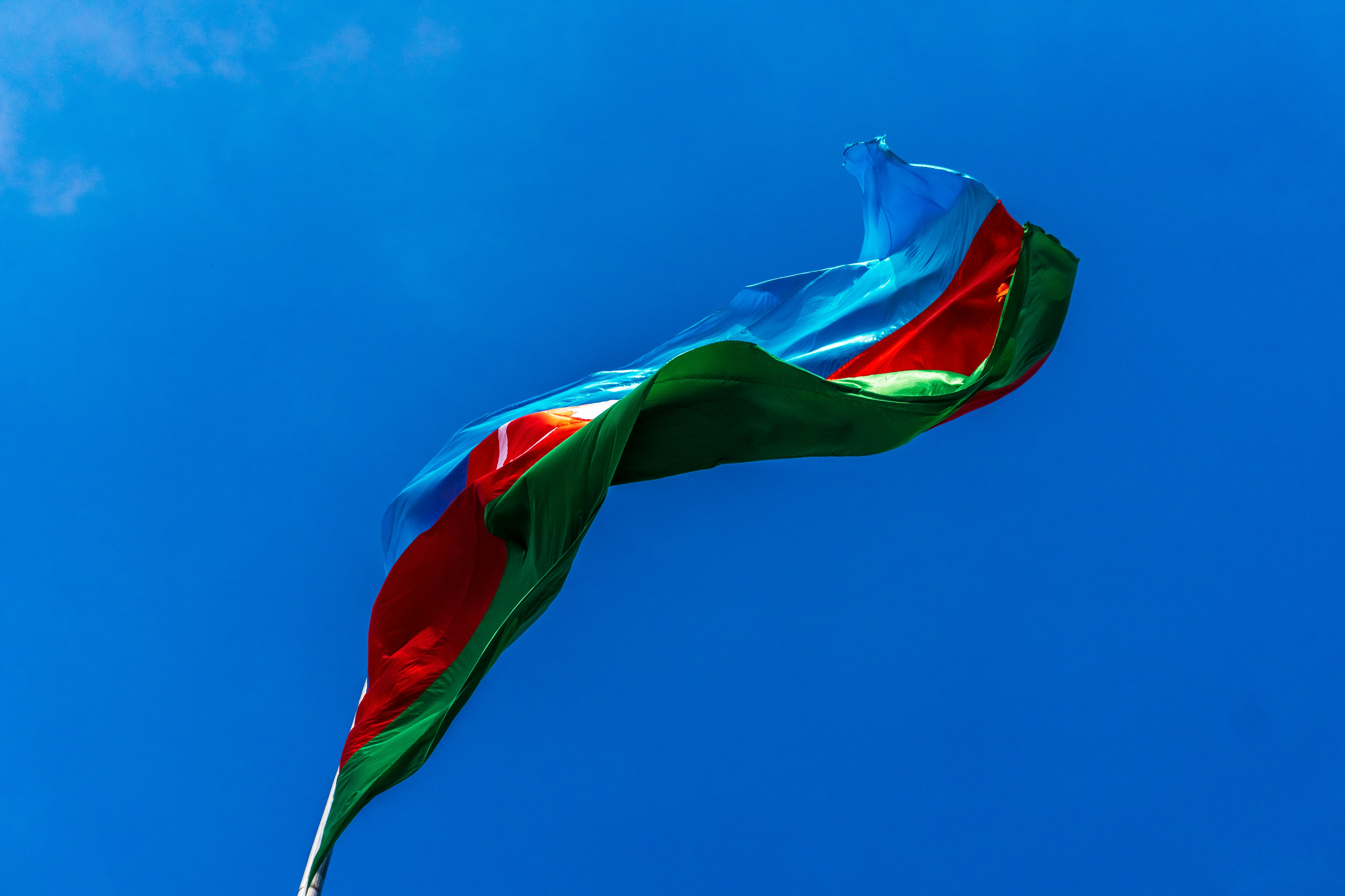 A flag waving against a clear blue sky