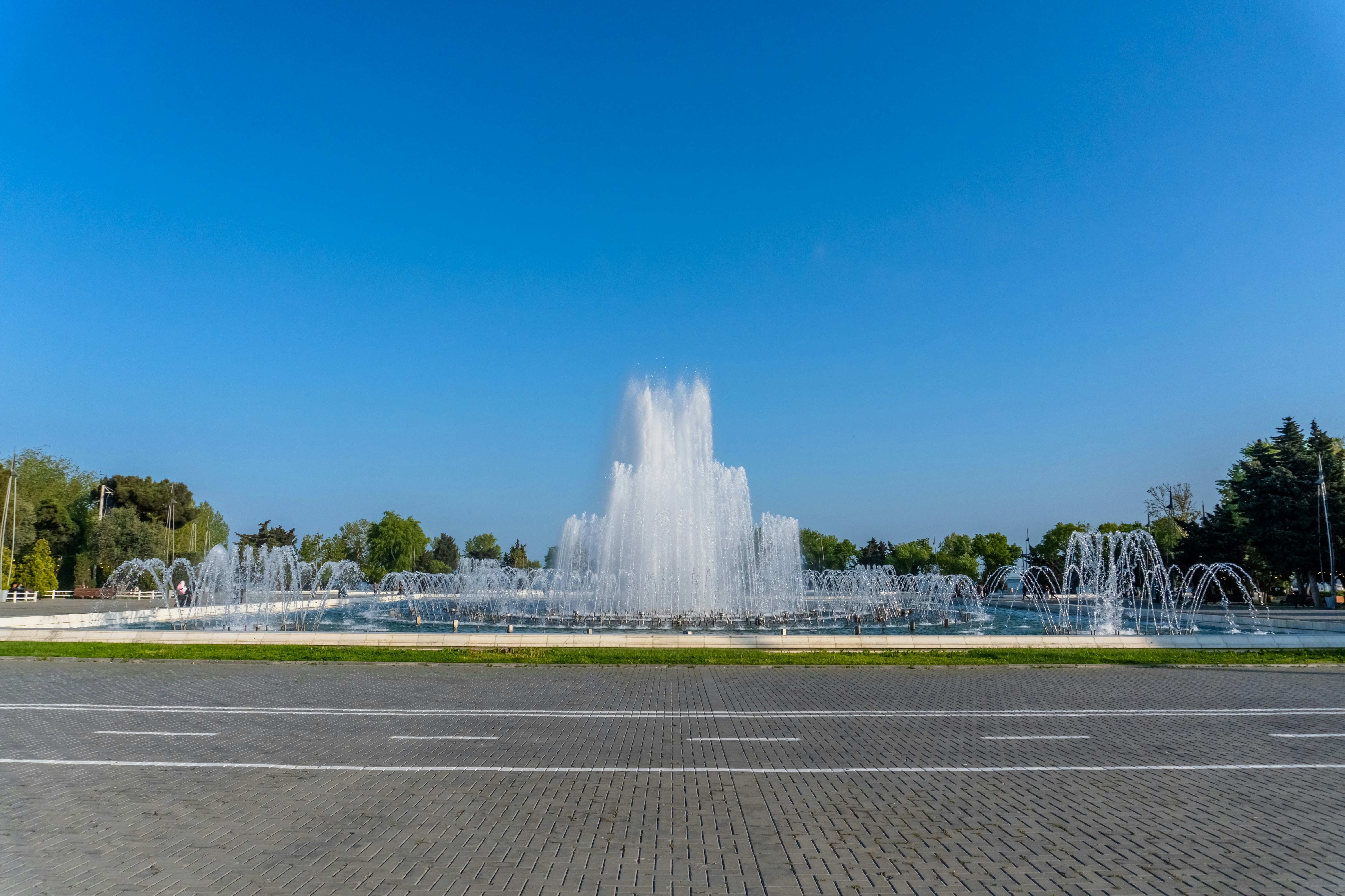 A large fountain spraying water under a clear blue sky.