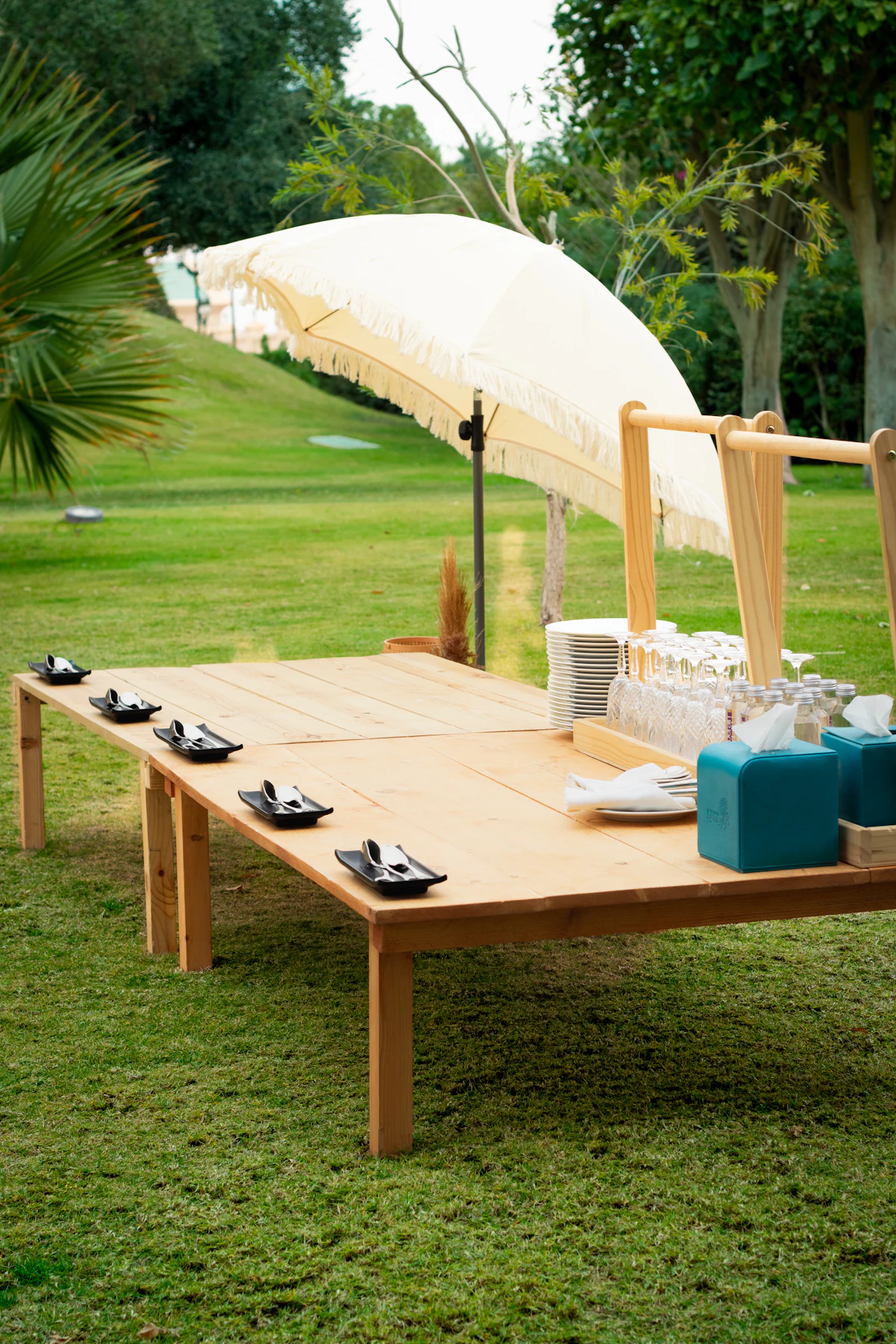 Mesa larga de madera preparada sobre el césped del jardín