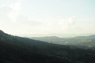 Rolling hills and mountains under a hazy sky