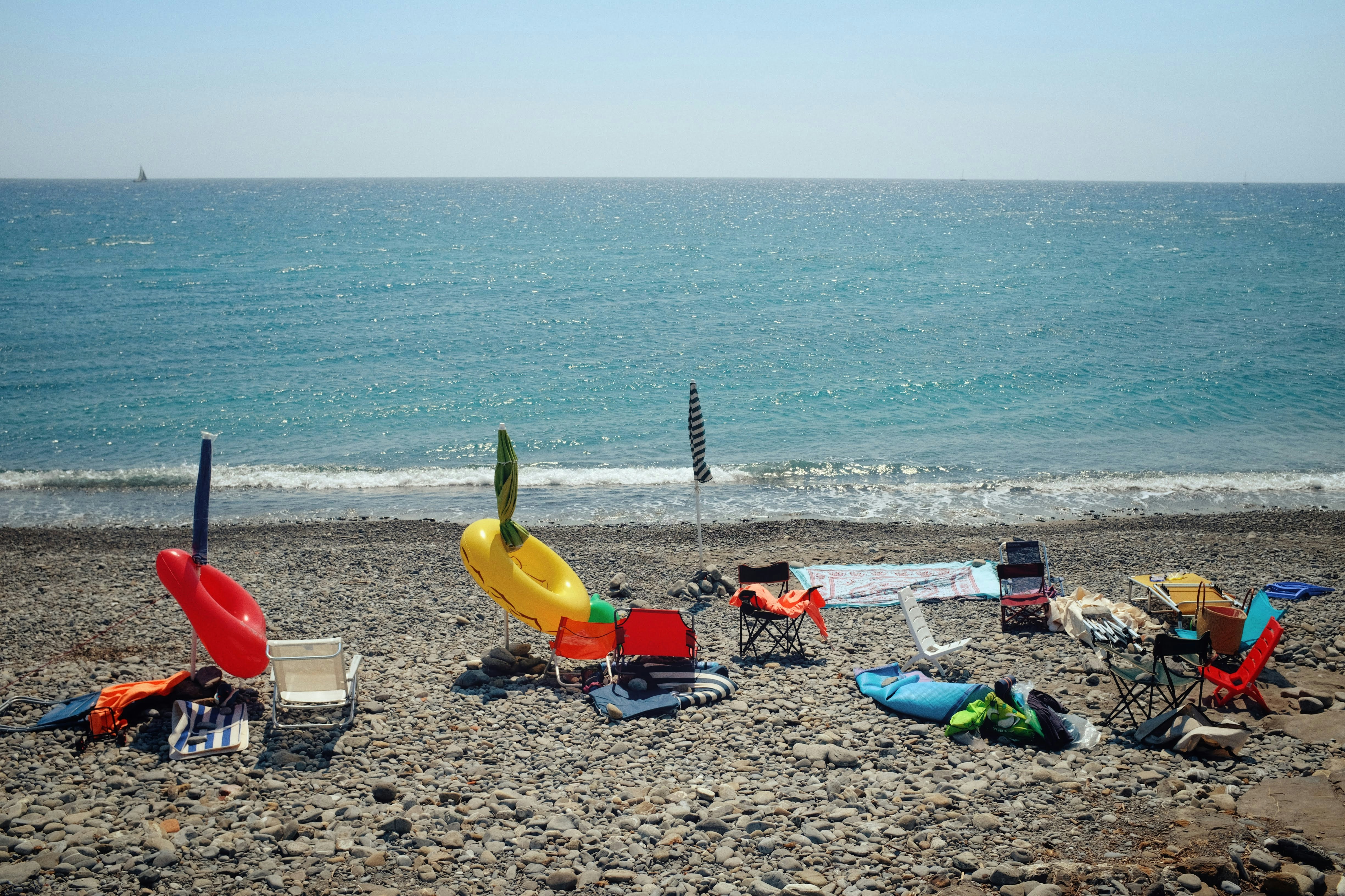 Beach chairs and toys scattered on a pebble beach
