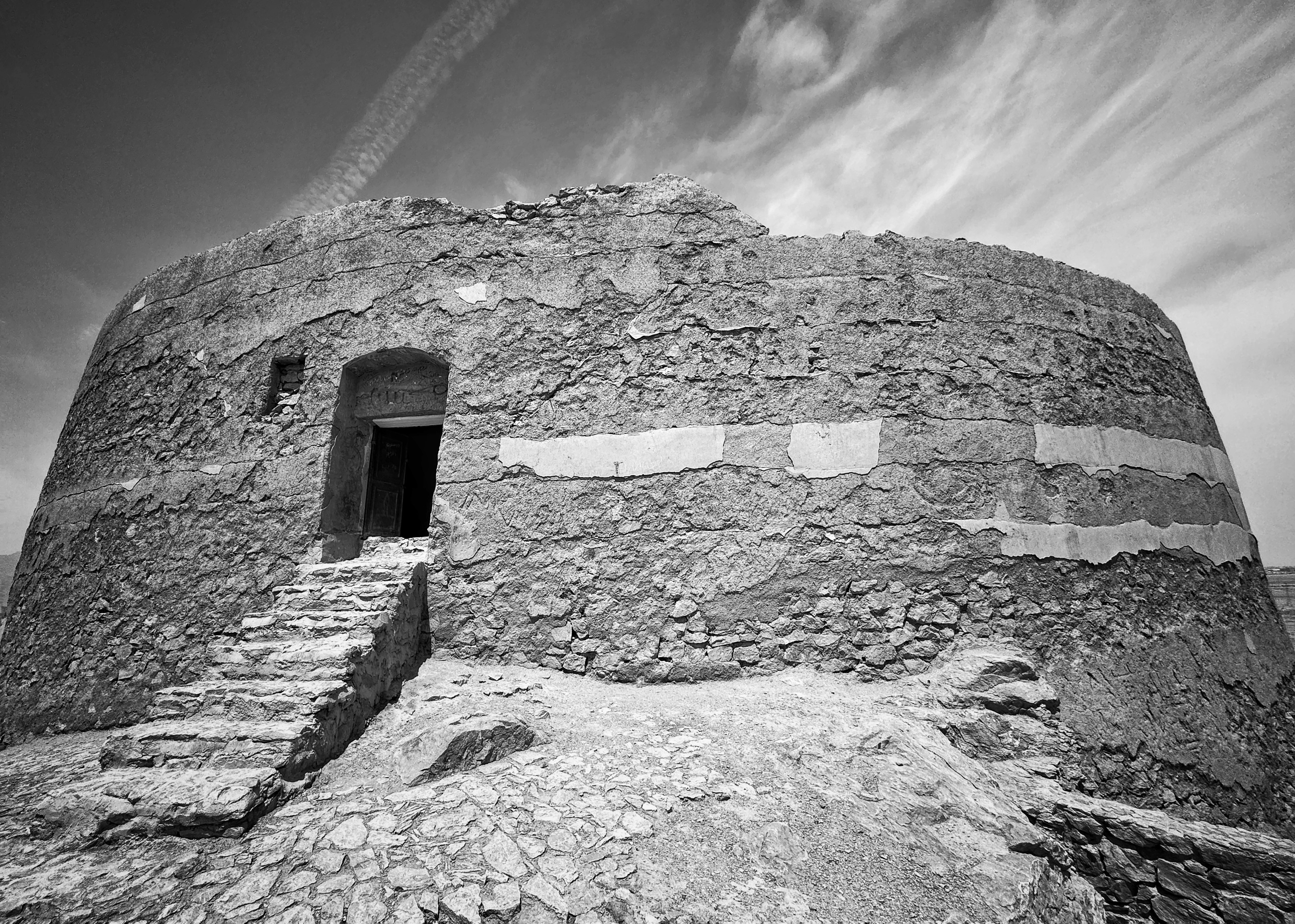 Ancienne tour en pierre avec escaliers et porte usés par le temps