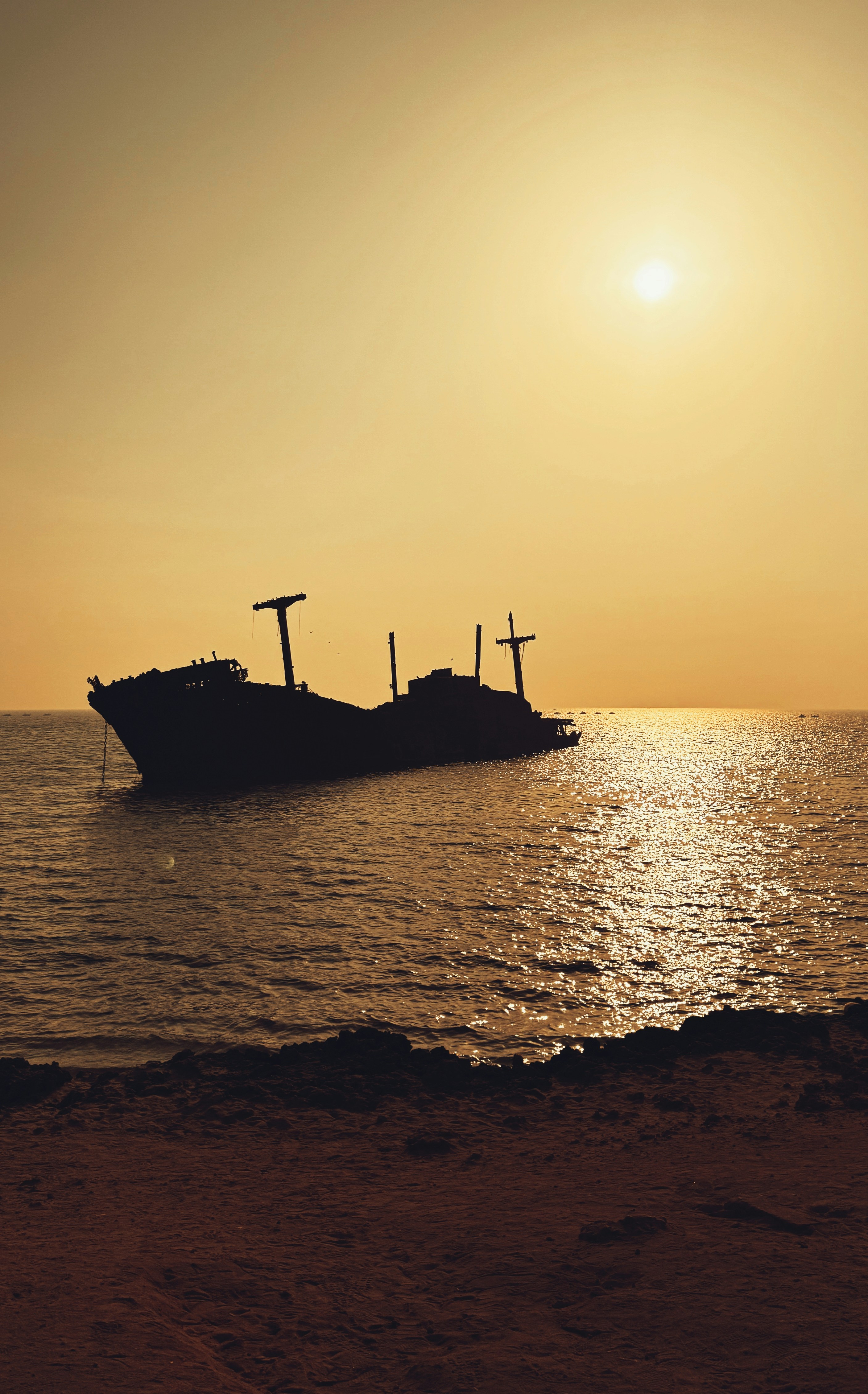 Silhouette d’épave au coucher du soleil sur l’océan.