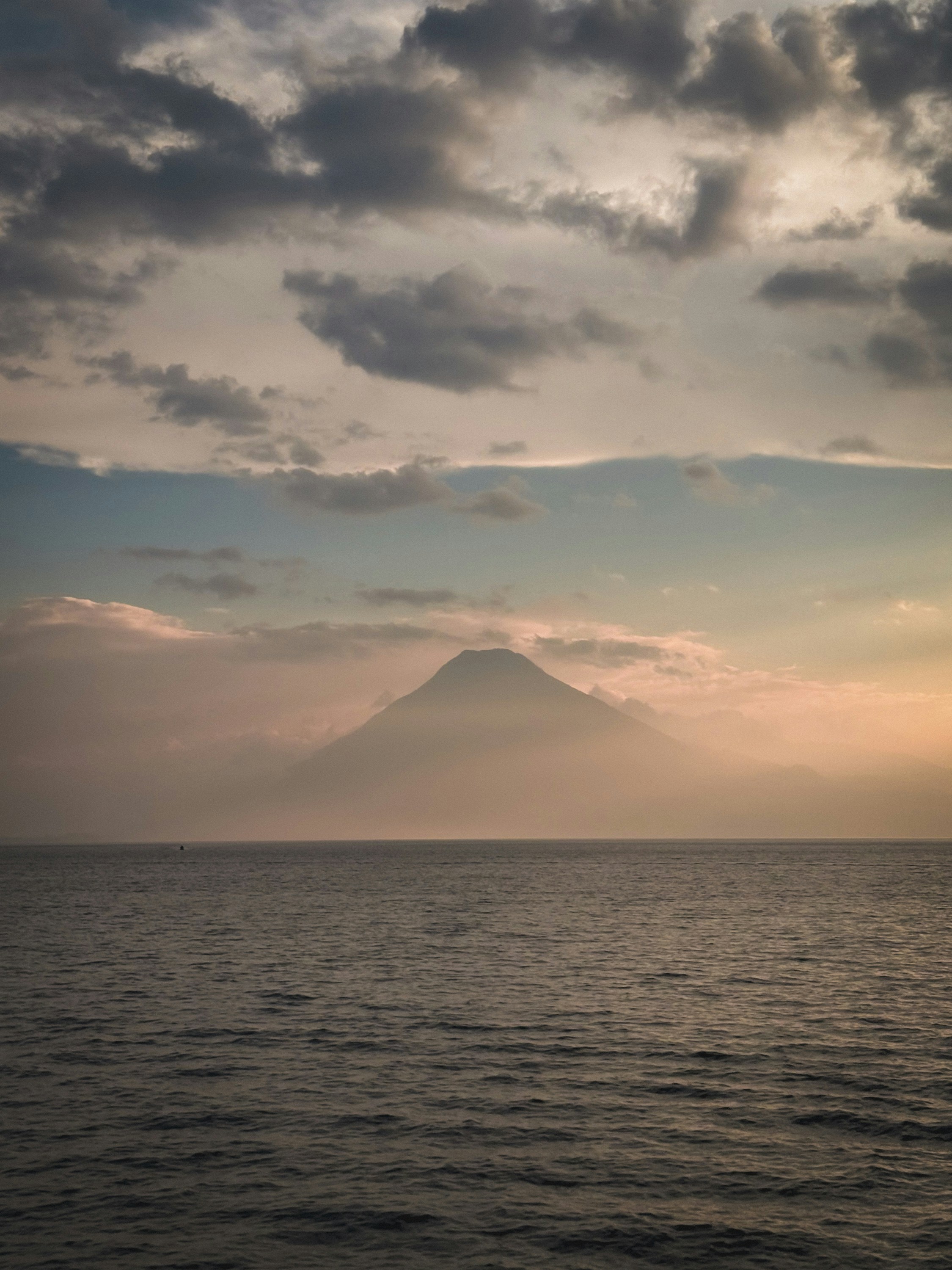 Silhouette volcanique au-dessus de l’océan au coucher du soleil