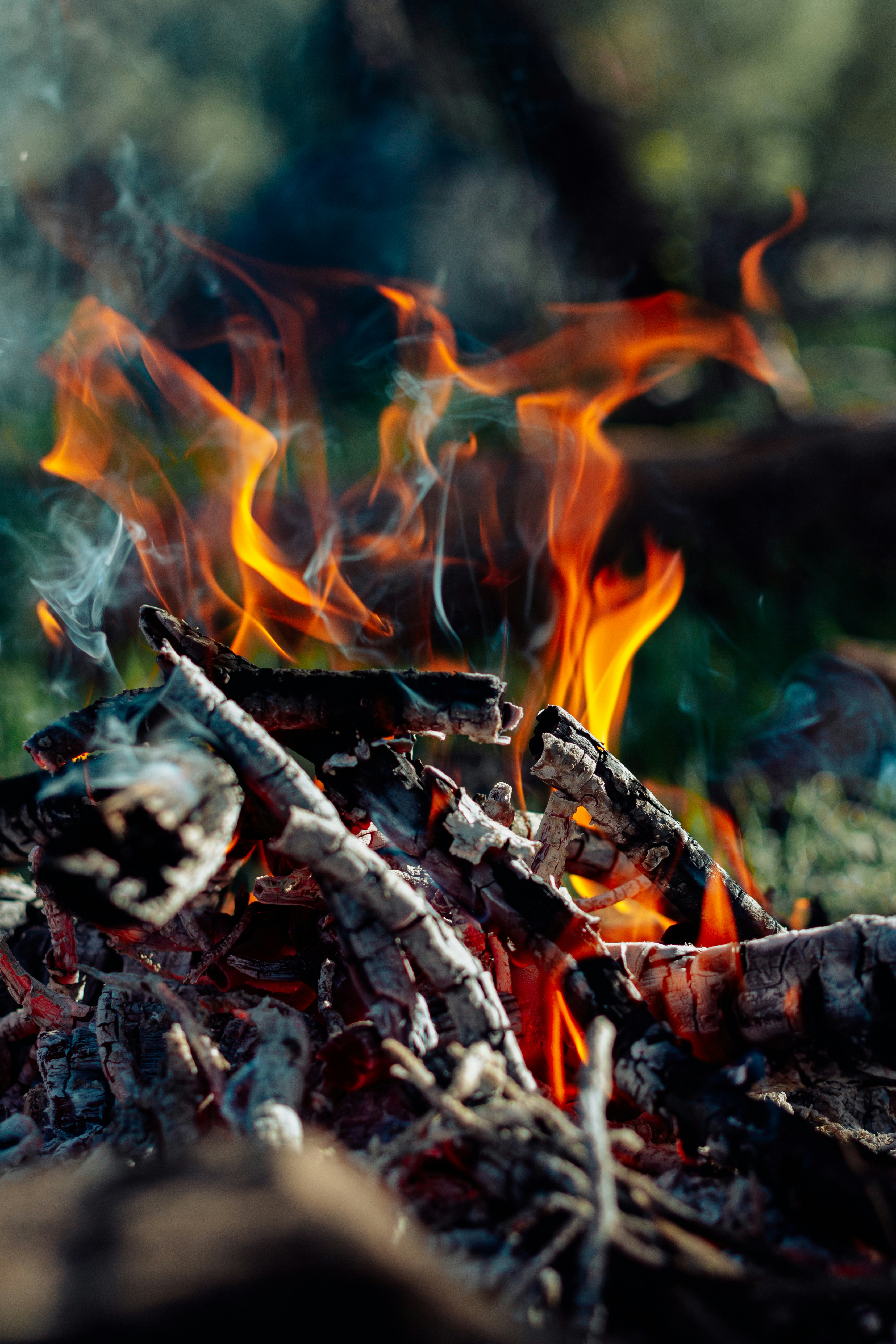 Un falò da campo arde intenso con il fumo che si alza.
