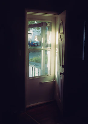 Sunlight streams through an open doorway onto a street