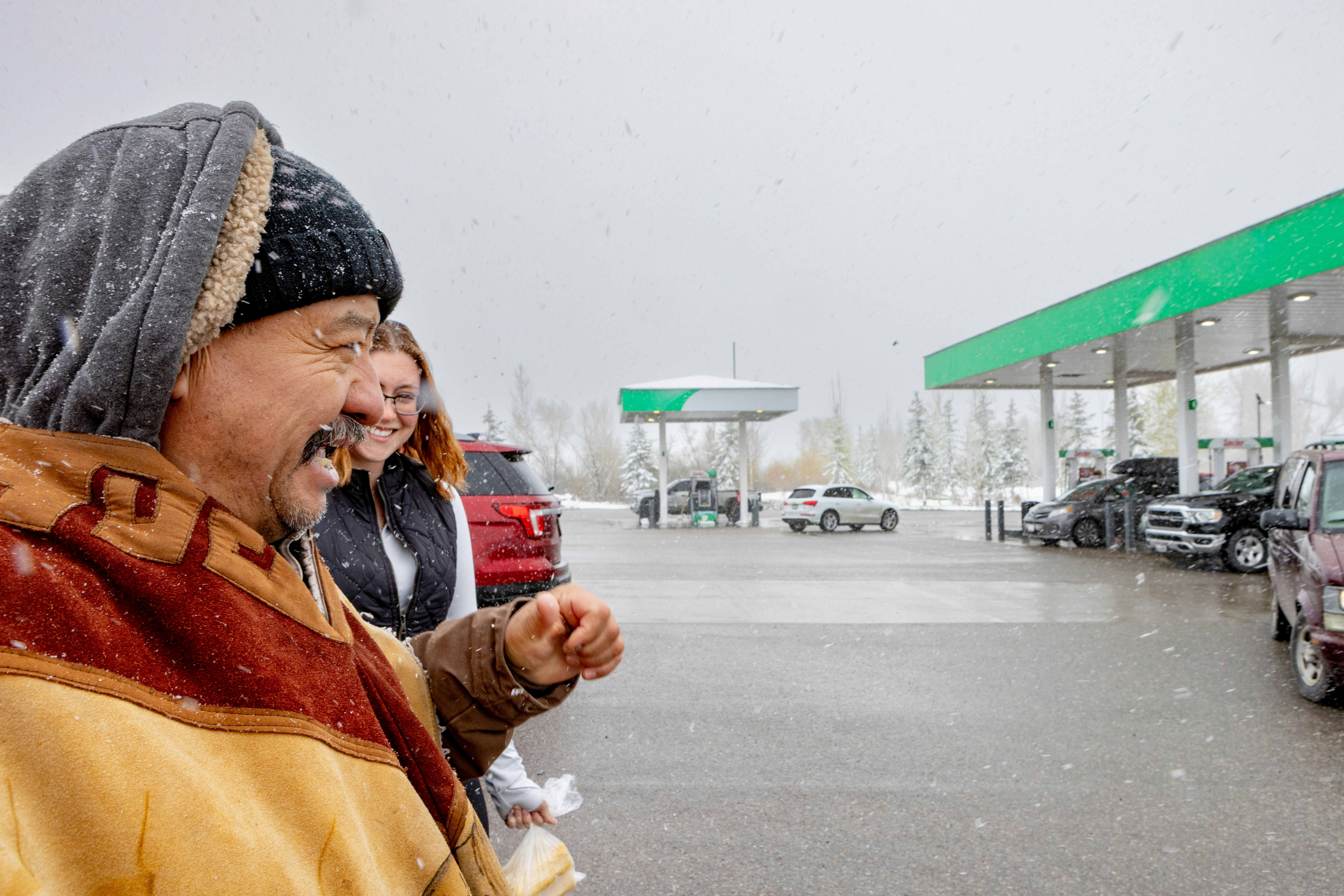 People at a gas station in the snow