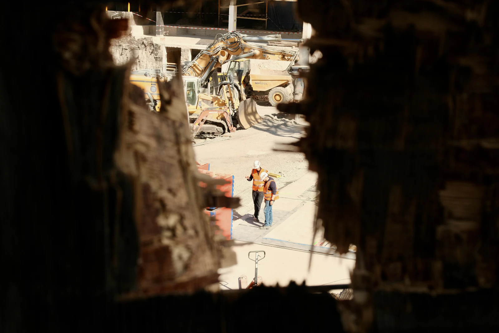 Construction workers observing heavy machinery on an industrial site